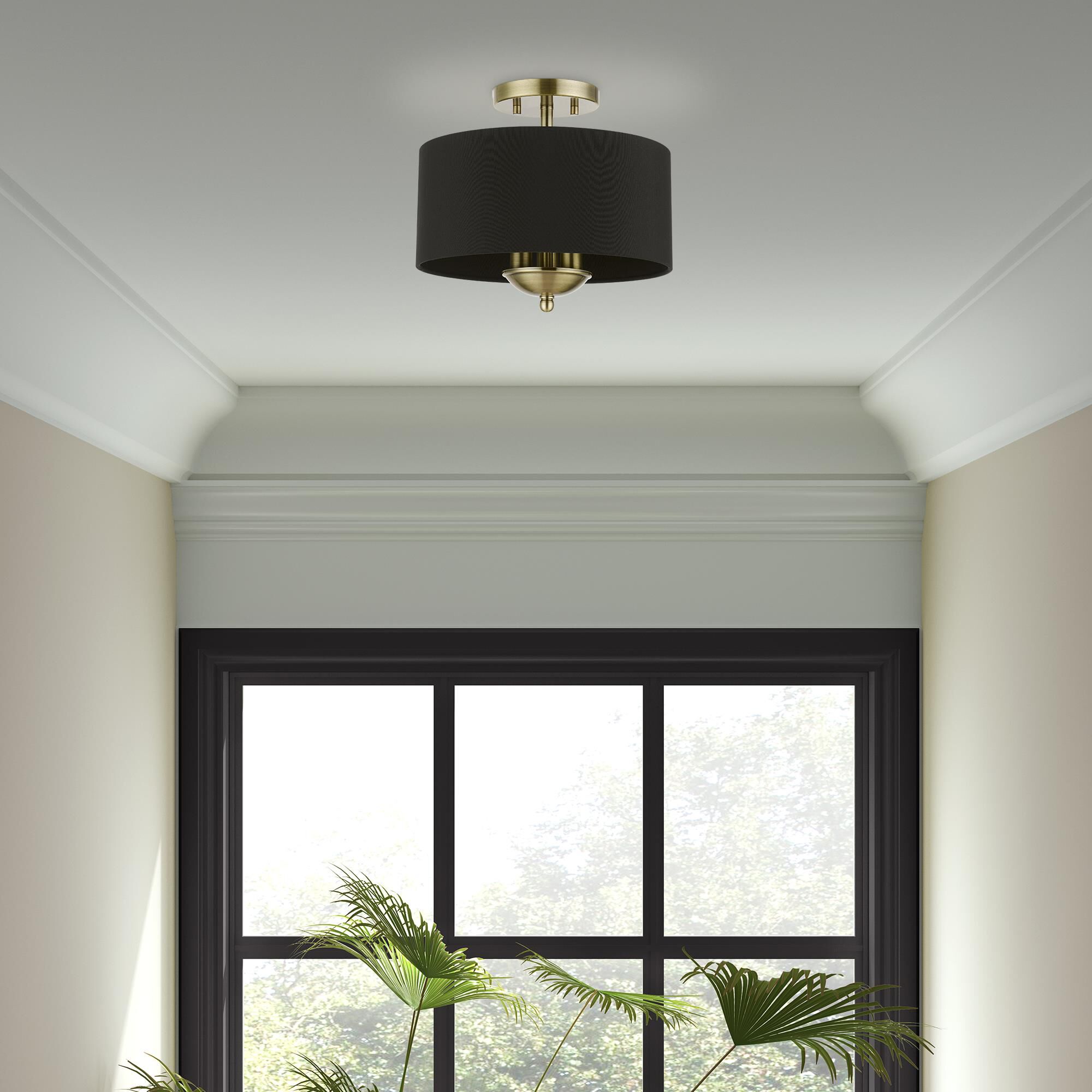 Shown in Antique Brass finish and Black Fabric Hardback shade
