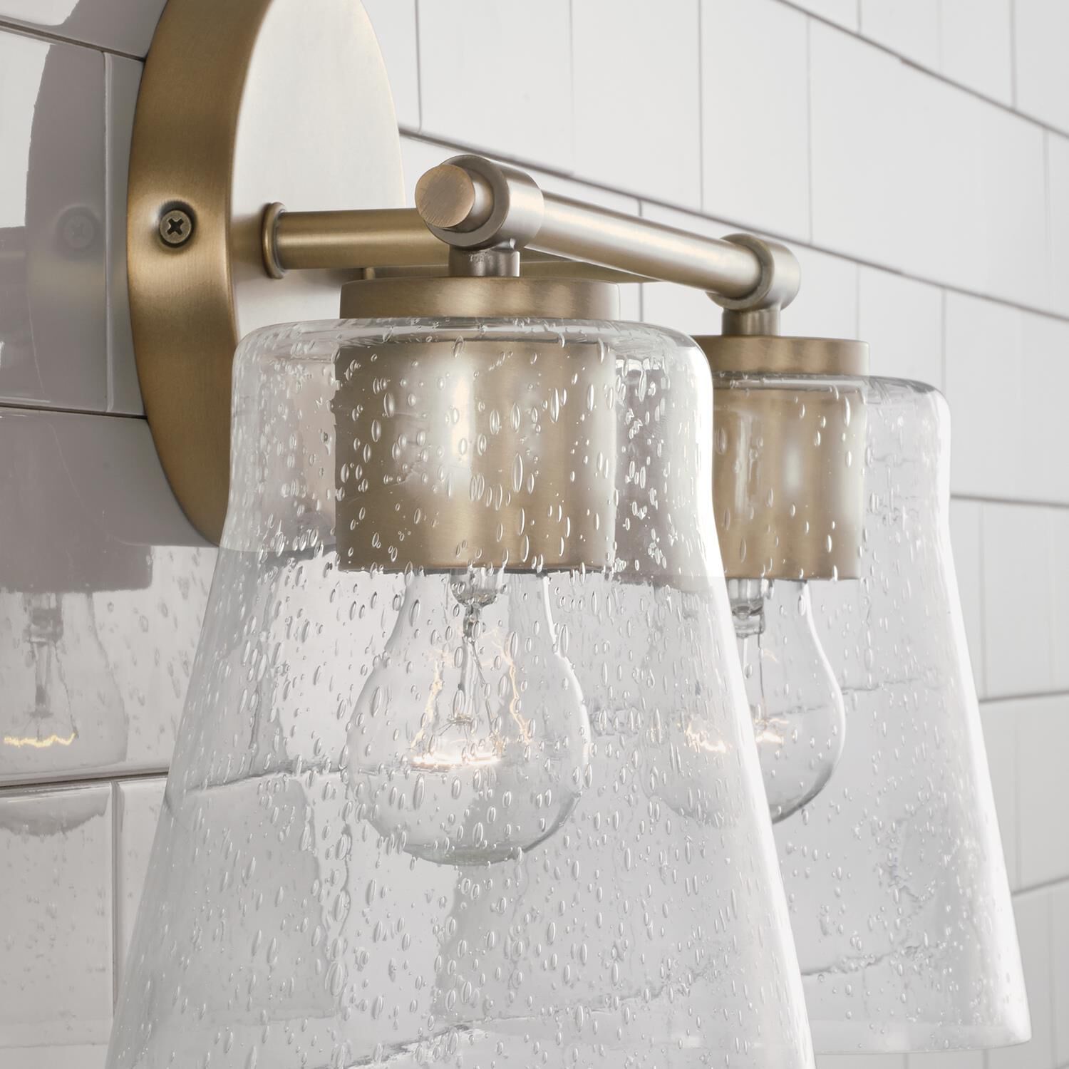 Shown in Aged Brass finish and Clear Seeded glass