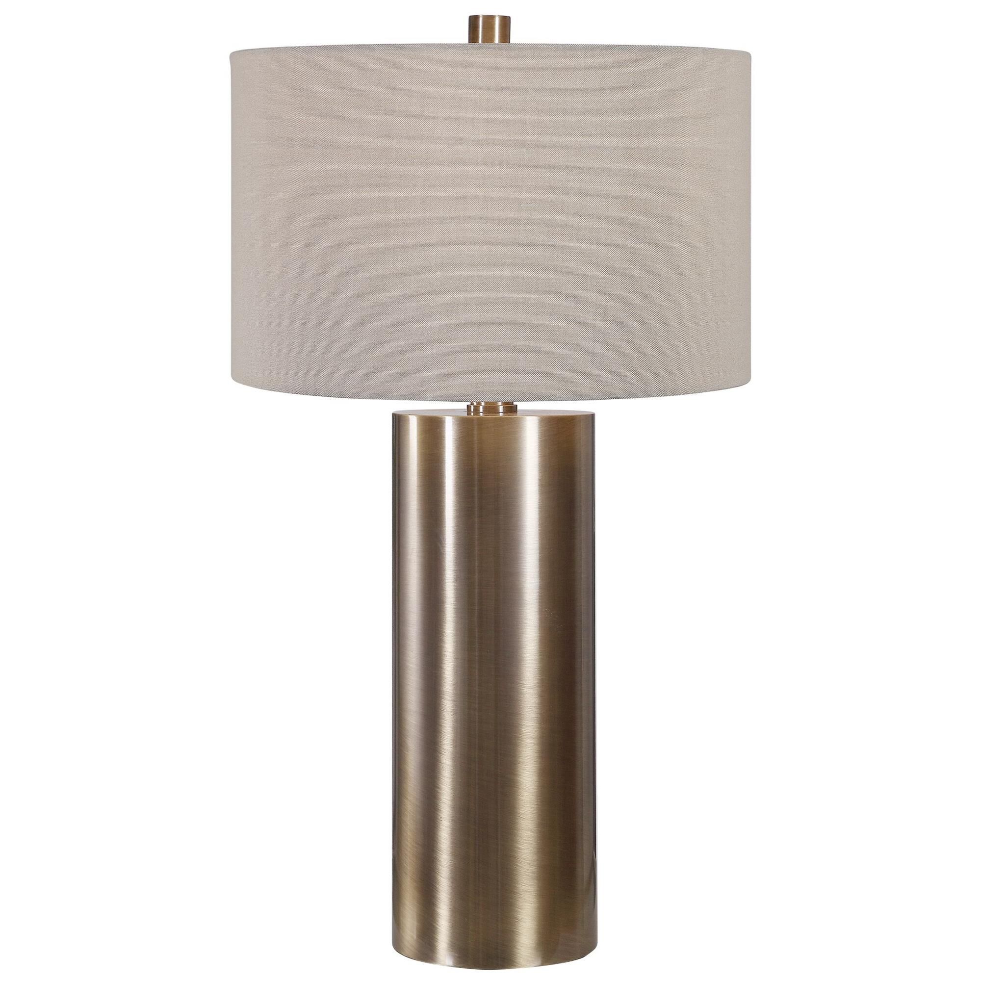 Shown in Finished In An Antiqued Brushed Brass, This Table Lamp Keeps It Simple Yet Upscale With A Large Meta finish and Round Drum Hardback shade
