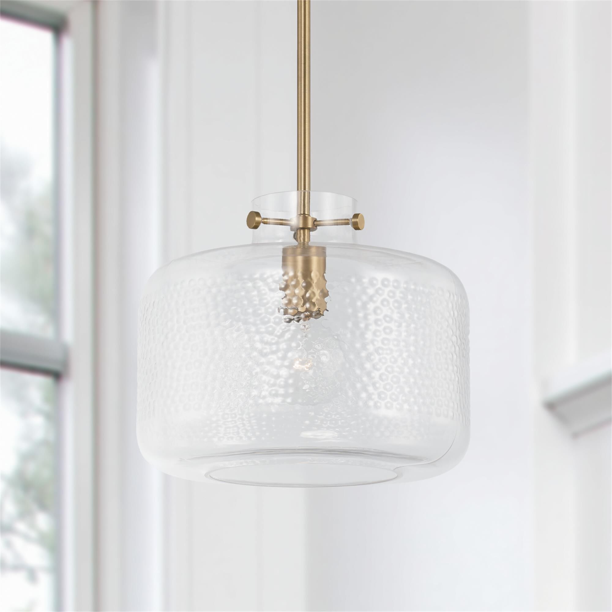 Shown in Aged Brass finish and Clear Pebbled glass