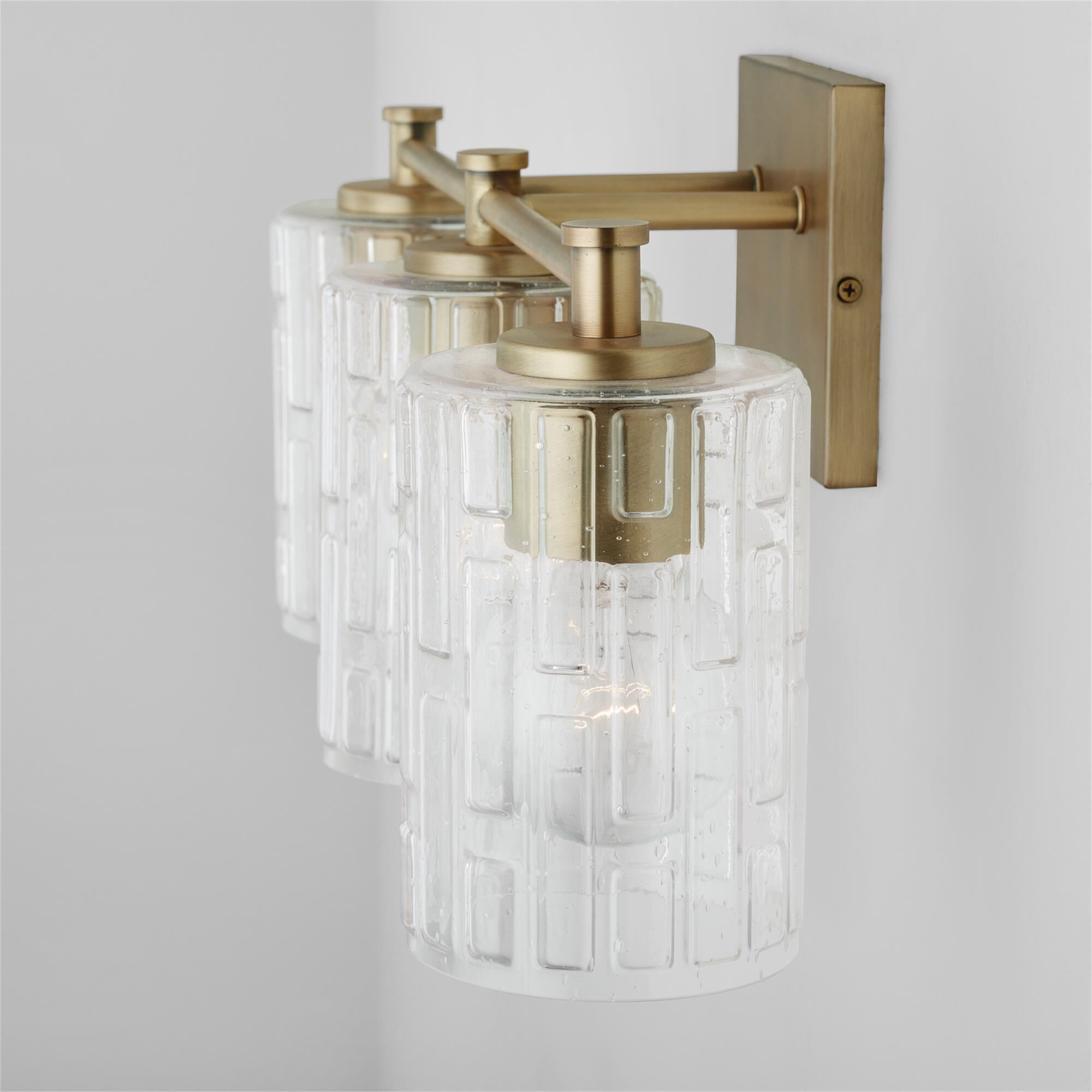 Shown in Aged Brass finish and Clear Embossed glass