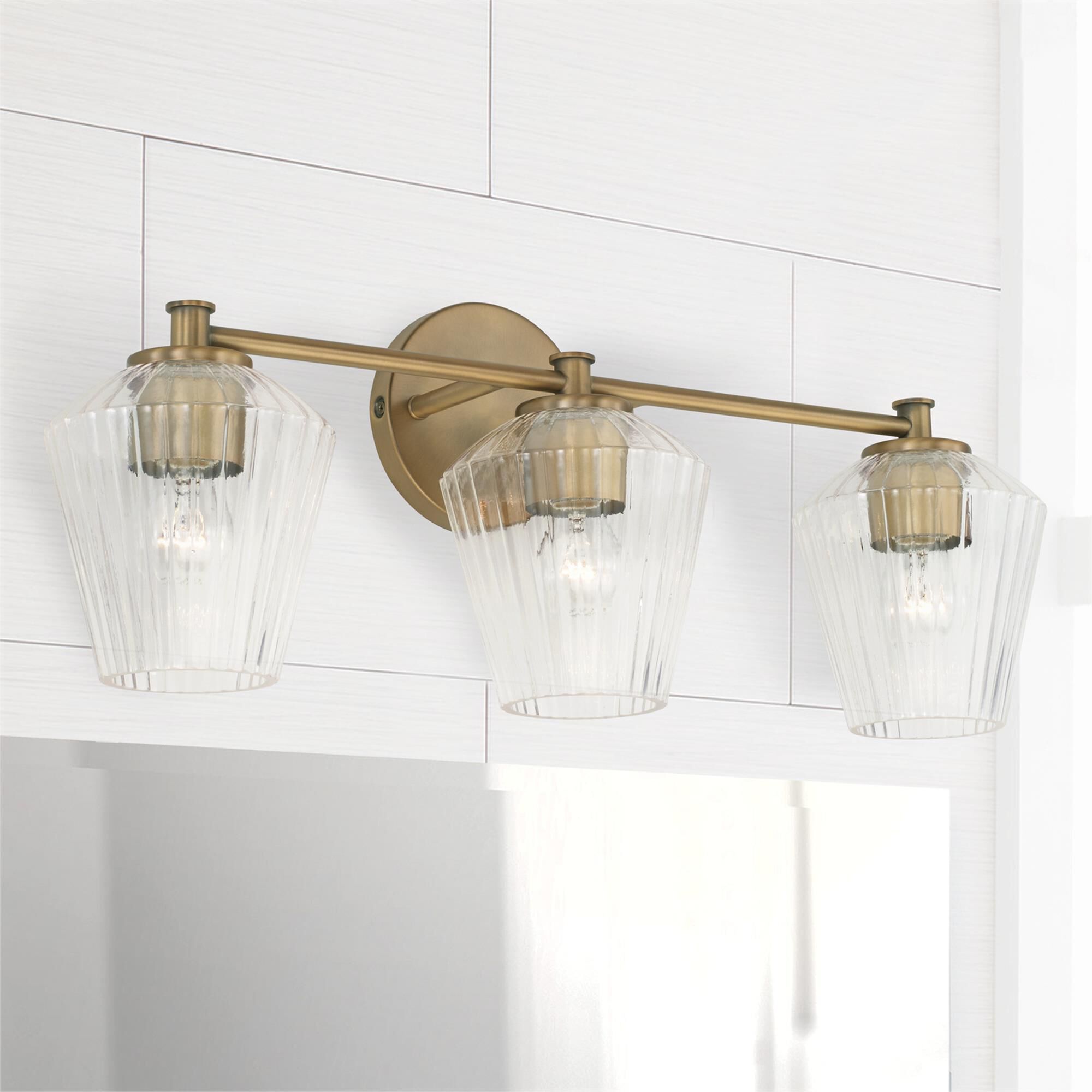 Shown in Aged Brass finish and Clear Fluted glass