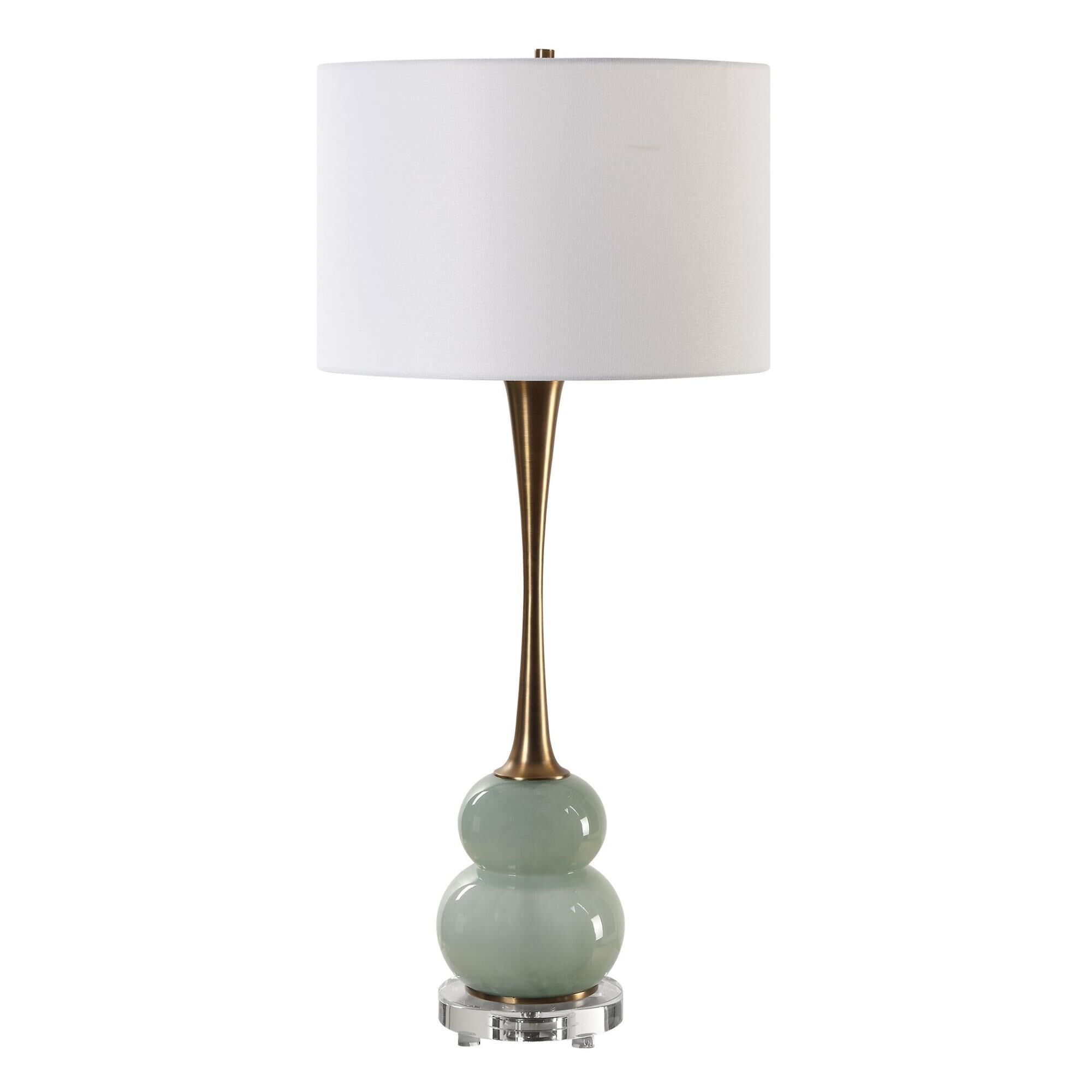 Shown in The Sanctuary Table Lamp Features A Curvy, Greenish-Gray Glass Body Paired With A Fluted Style Neck  finish and Round Drum Hardback shade