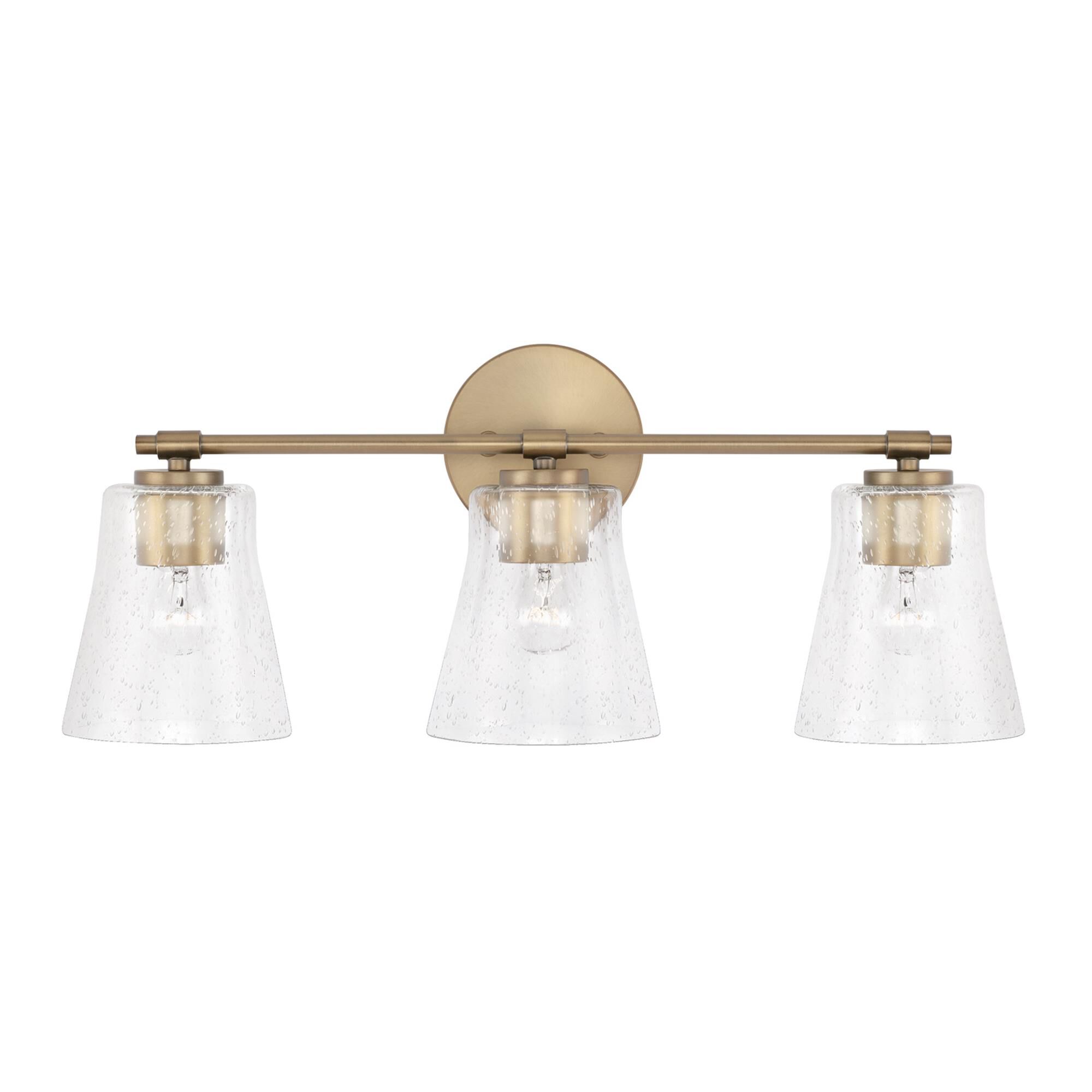 Shown in Aged Brass finish and Clear Seeded glass