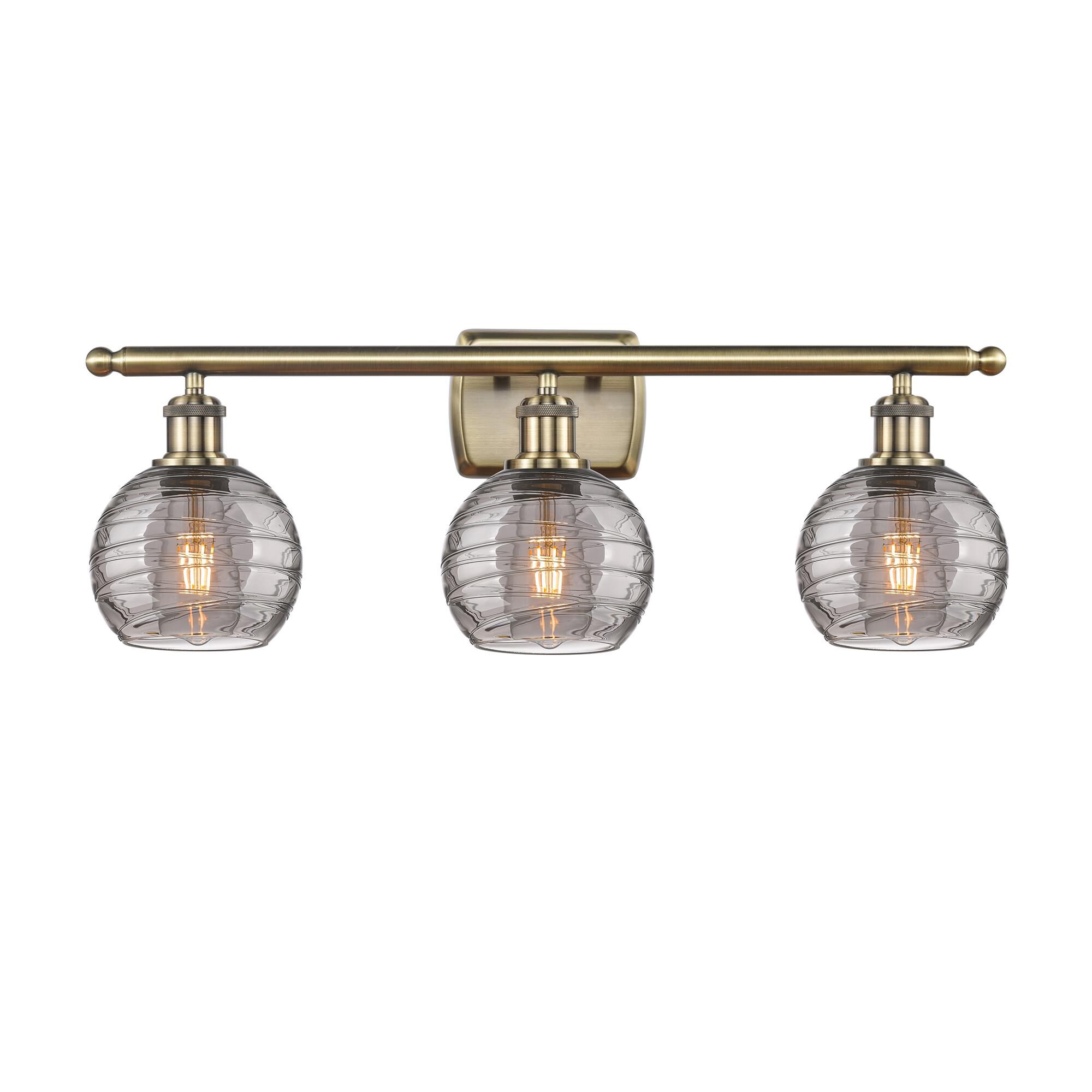 Shown in Antique Brass finish and Light Smoke Deco Swirl glass