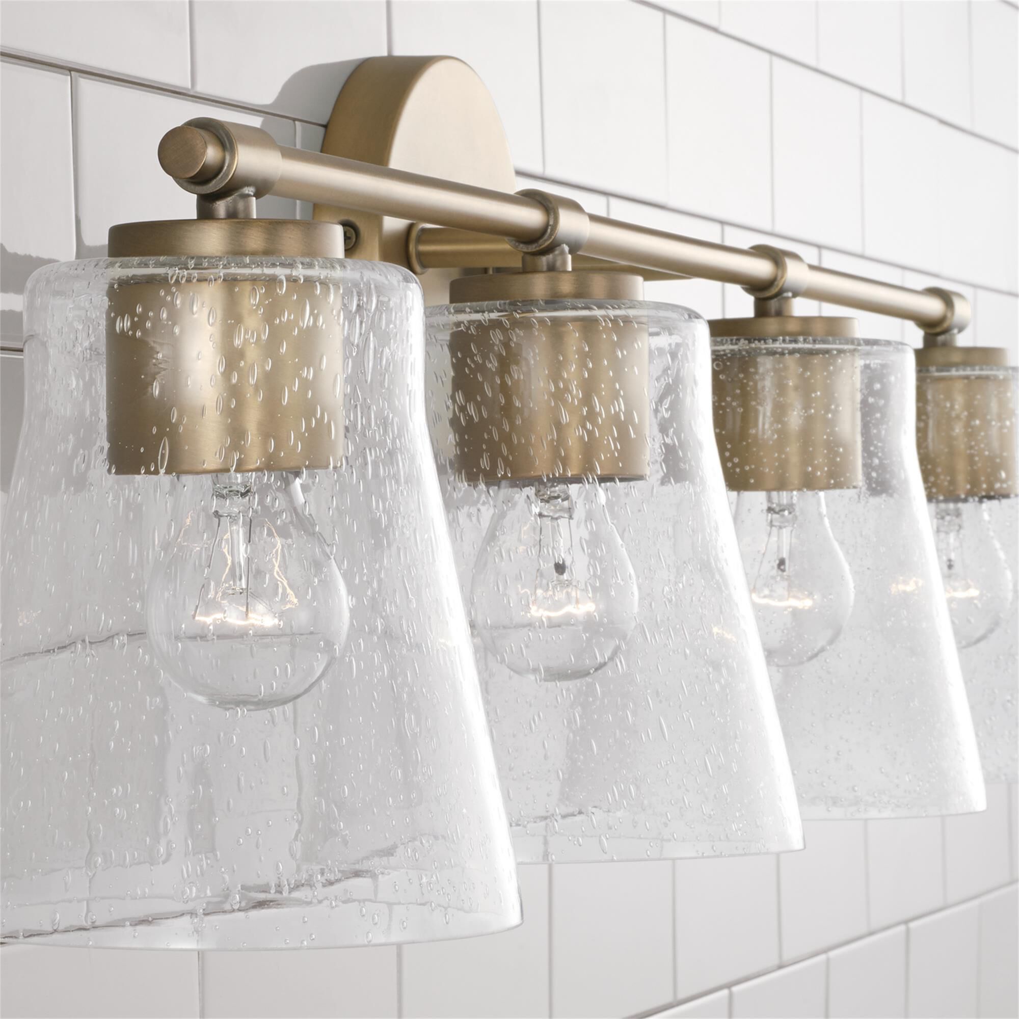 Shown in Aged Brass finish and Clear Seeded glass