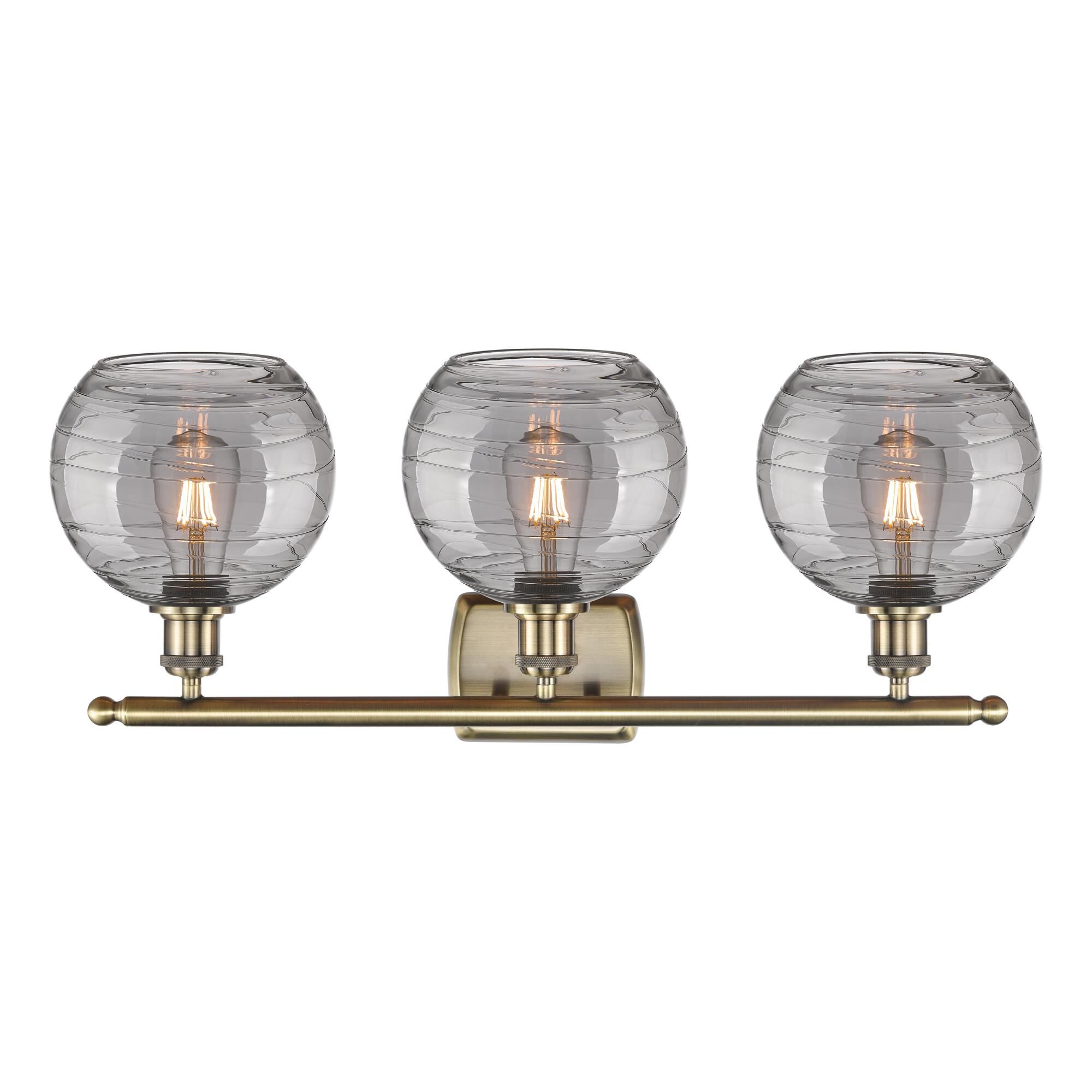 Shown in Antique Brass finish and Light Smoke Deco Swirl glass