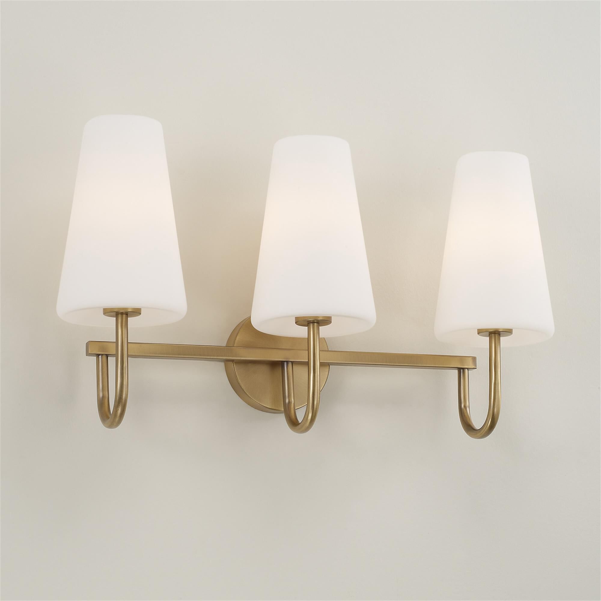 Shown in Aged Brass finish and Soft White glass