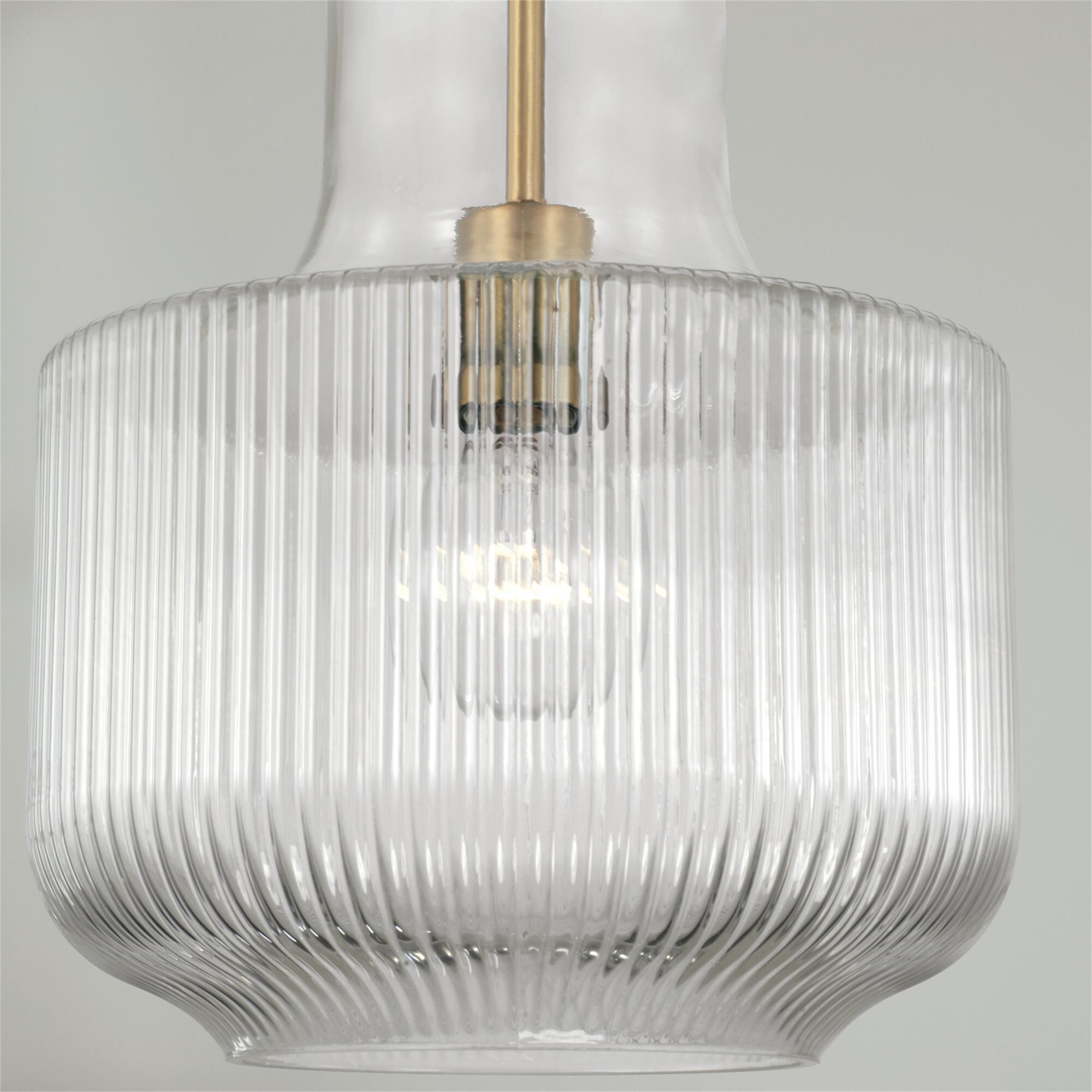 Shown in Aged Brass finish and Clear Fluted glass