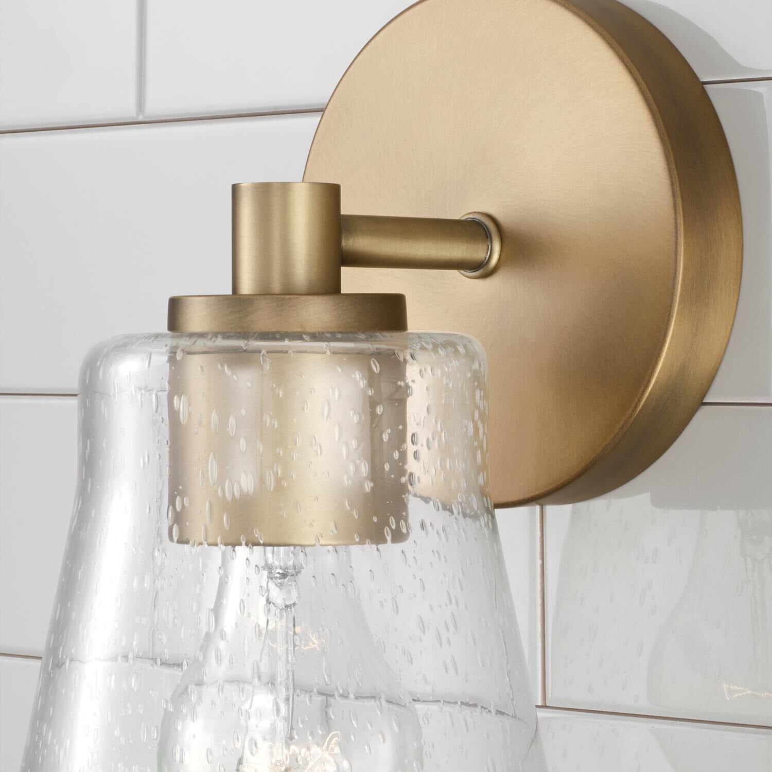 Shown in Aged Brass finish and Clear Seeded glass