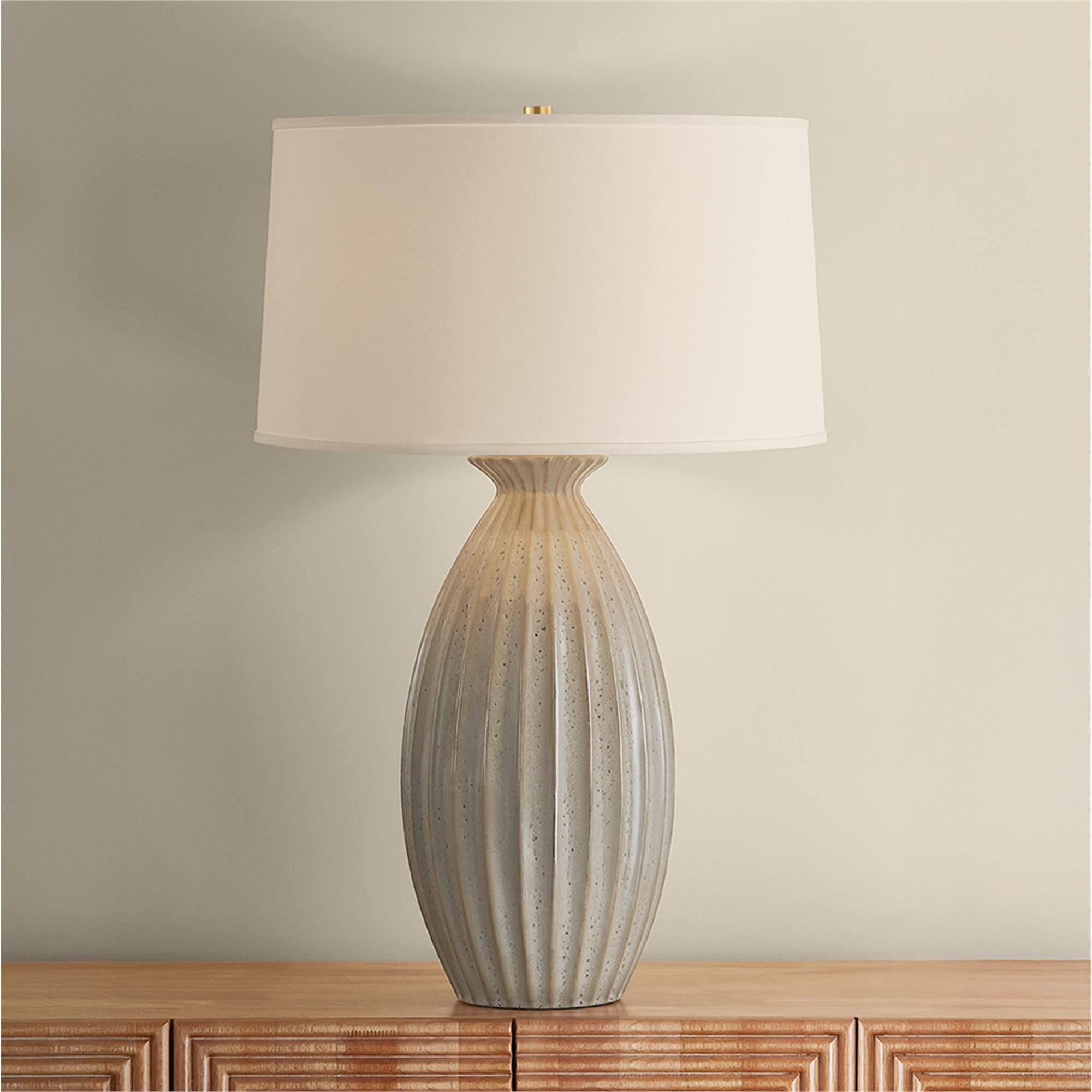 Shown in Aged Brass and Ceramic Taupe Velvet finish and White Linen shade