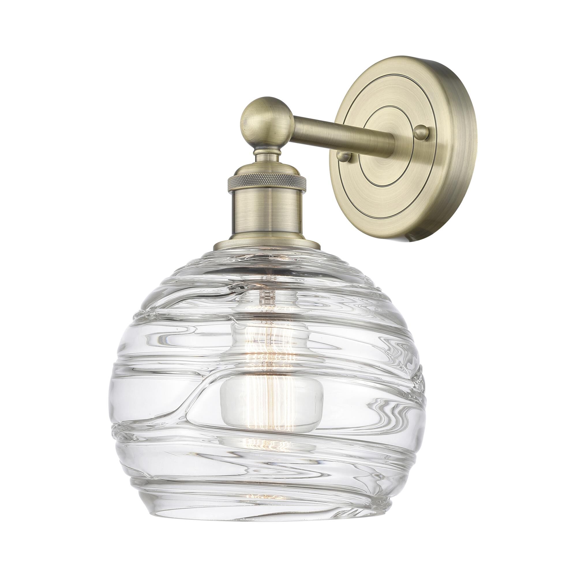 Shown in Antique Brass finish and Clear Deco Swirl glass