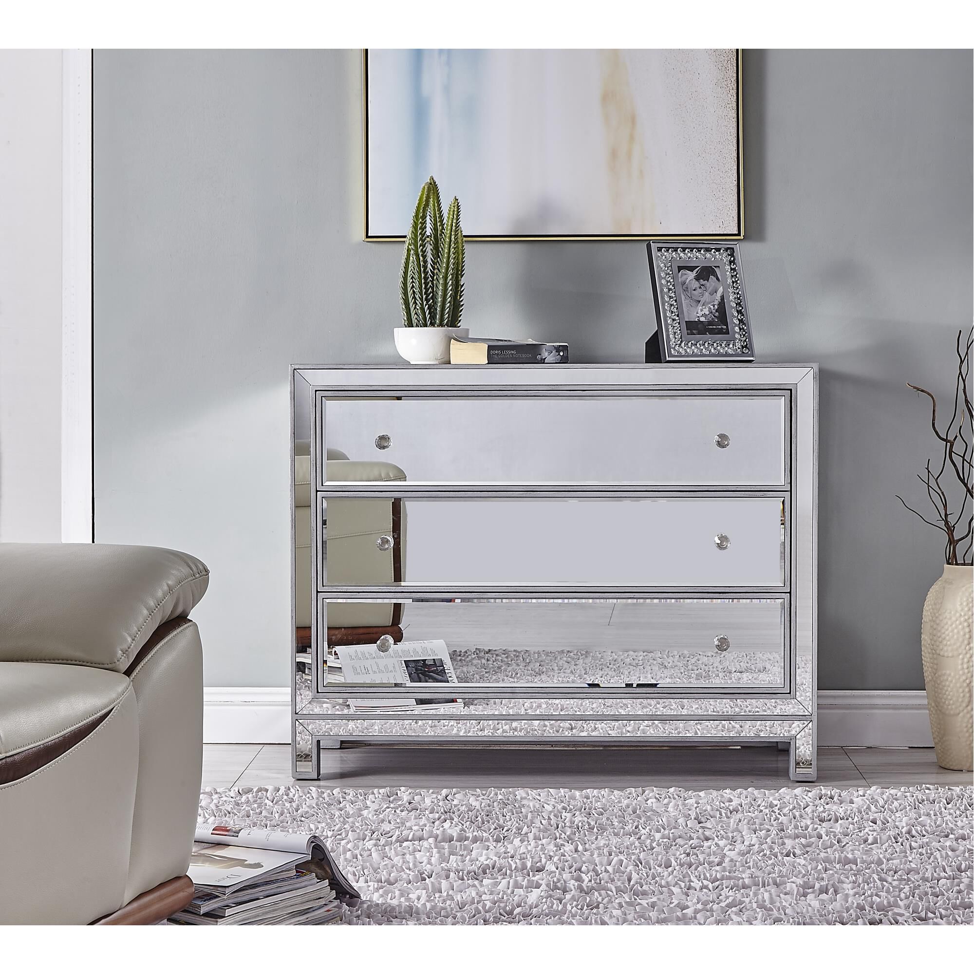 Mirrored storage cabinet with closed drawers in a living room setting.