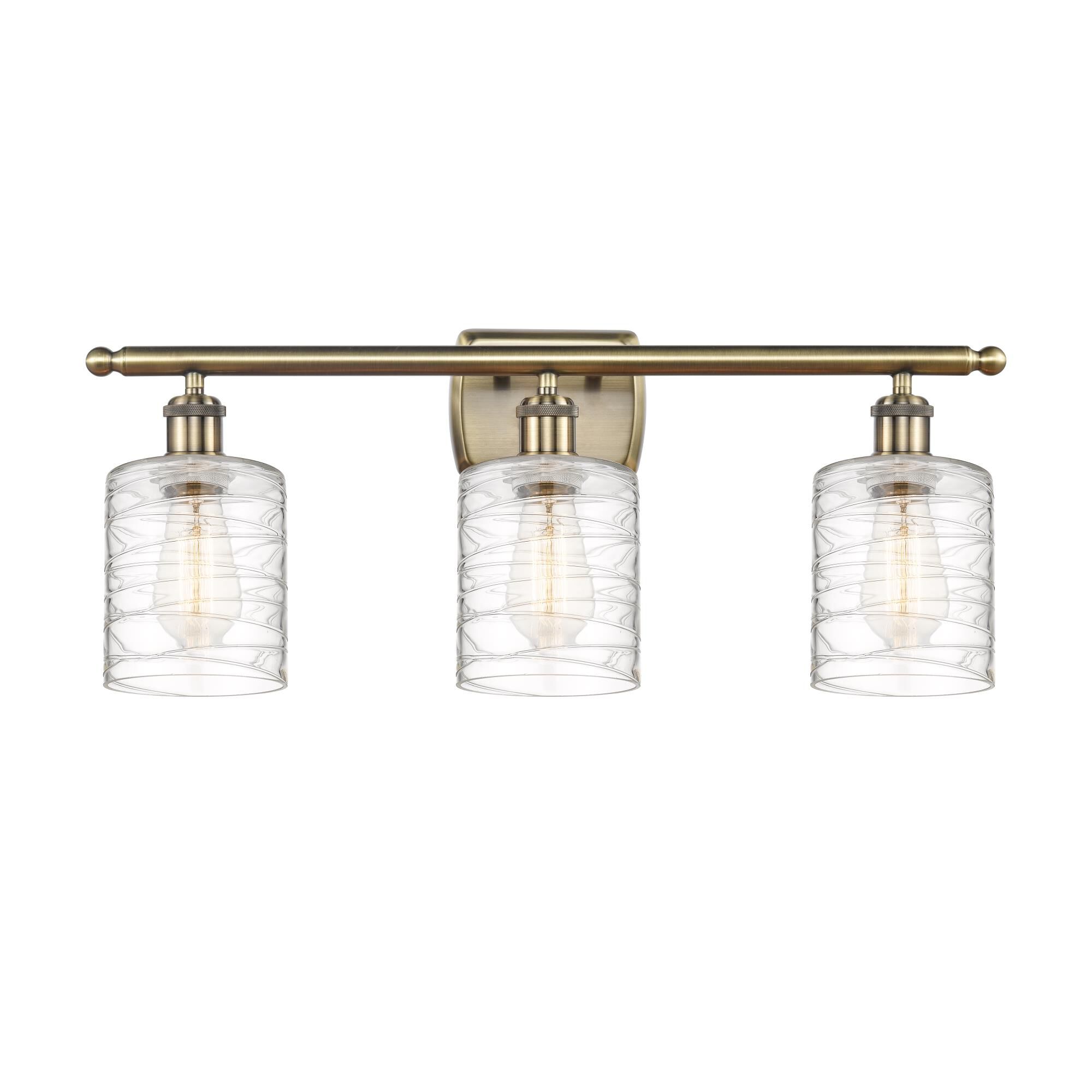 Shown in Antique Brass finish and Deco Swirl Cobbleskill glass