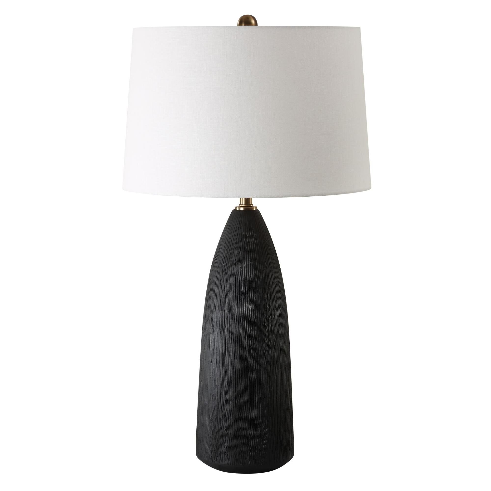 Shown in The Jett Table Lamp Showcases A Matte Black Ceramic Base With Organic Texturing, Accented With Plate finish and Round Hardback shade