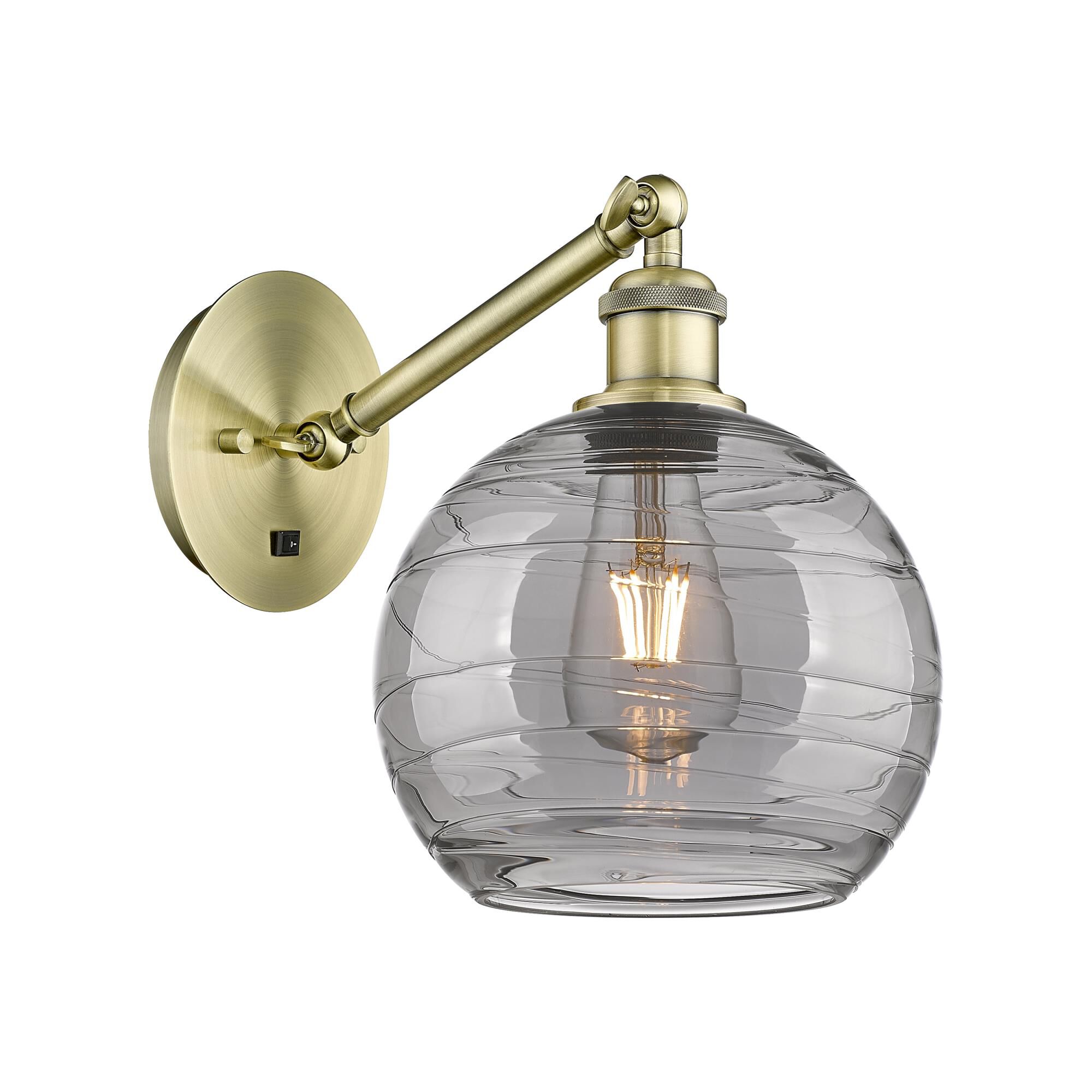 Shown in Antique Brass finish and Light Smoke Deco Swirl glass
