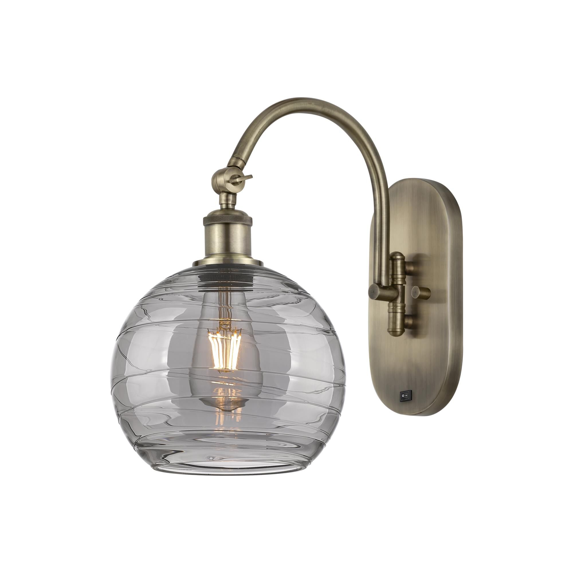 Shown in Antique Brass finish and Light Smoke Deco Swirl glass