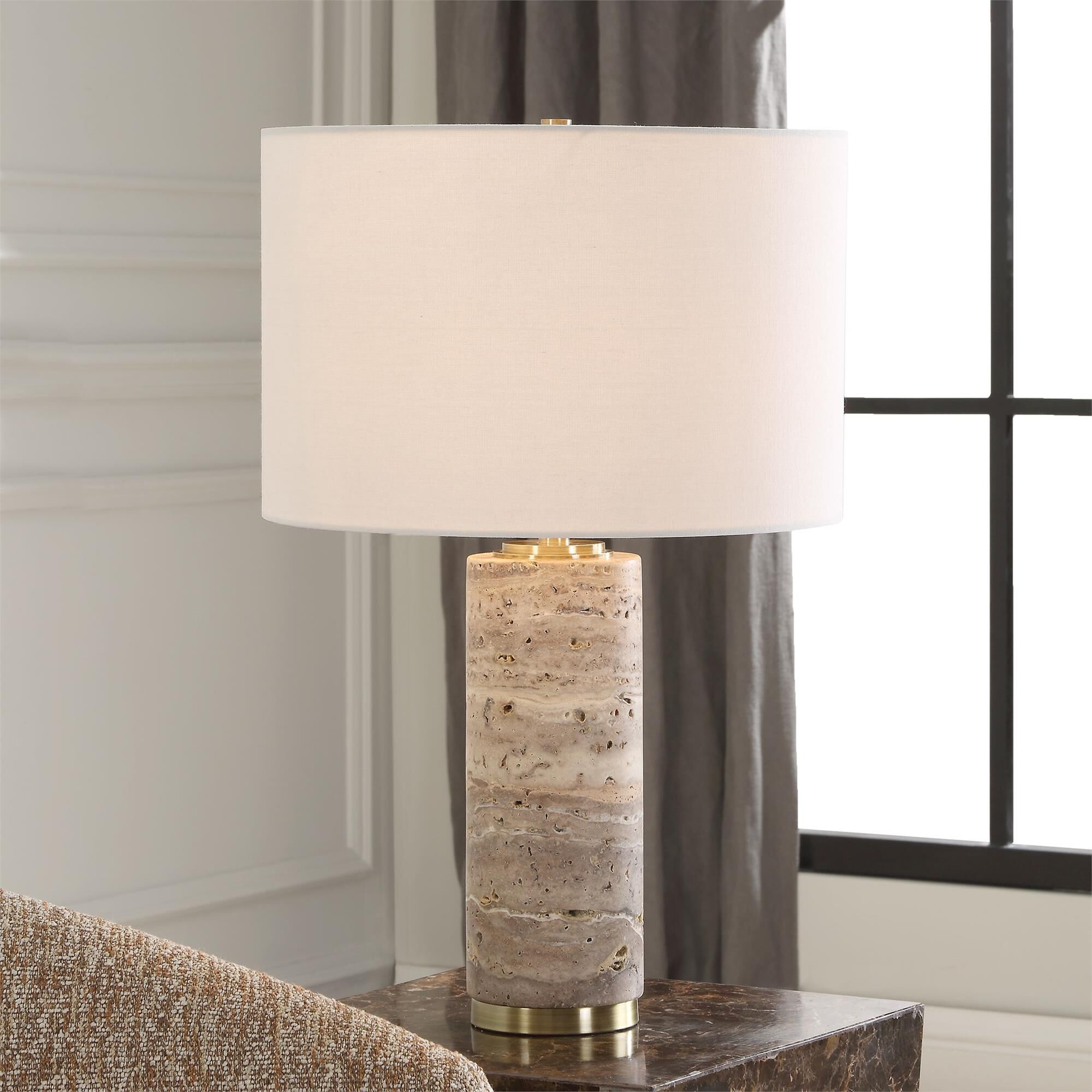 Shown in Featuring An Unfilled Honed Travertine Base Paired With Sophisticated Plated Antique Brass Accents.  finish and Round Hardback Drum shade