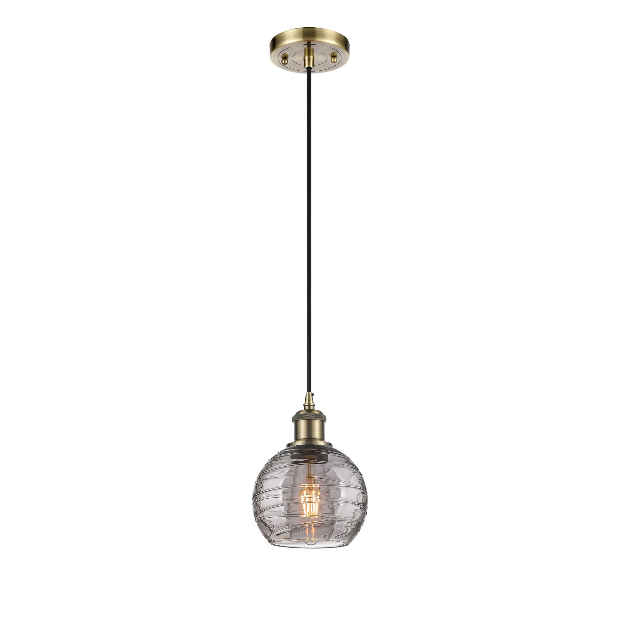 Shown in Antique Brass finish and Light Smoke Deco Swirl glass