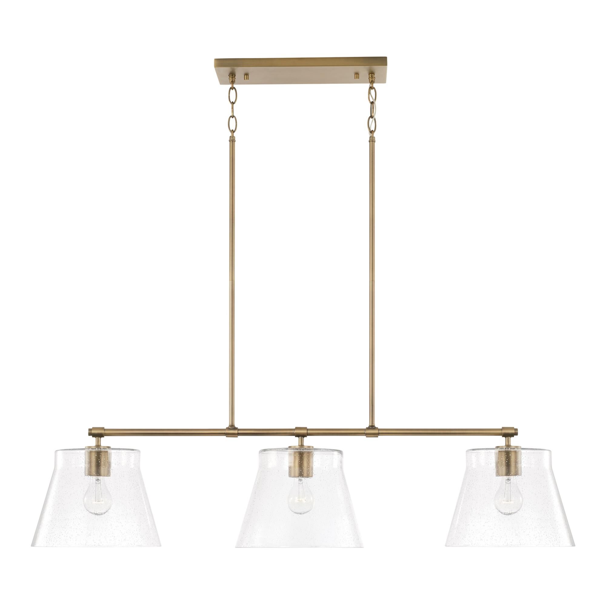 Shown in Aged Brass finish and Clear Seeded glass