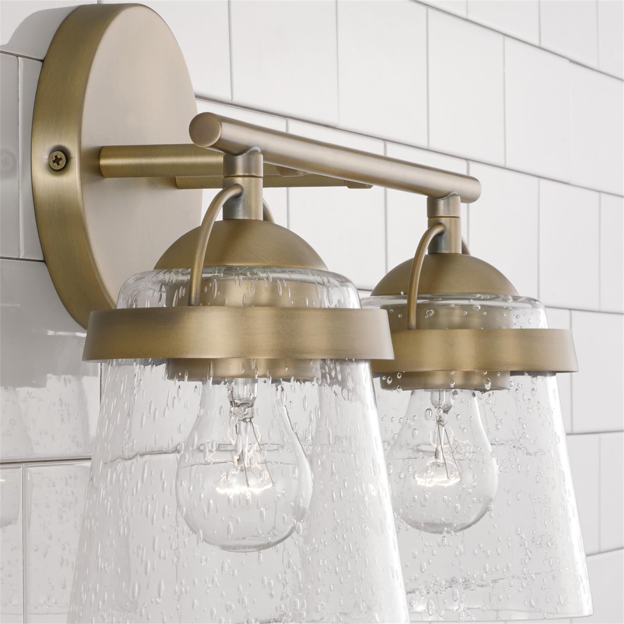 Shown in Aged Brass finish and Clear Seeded glass