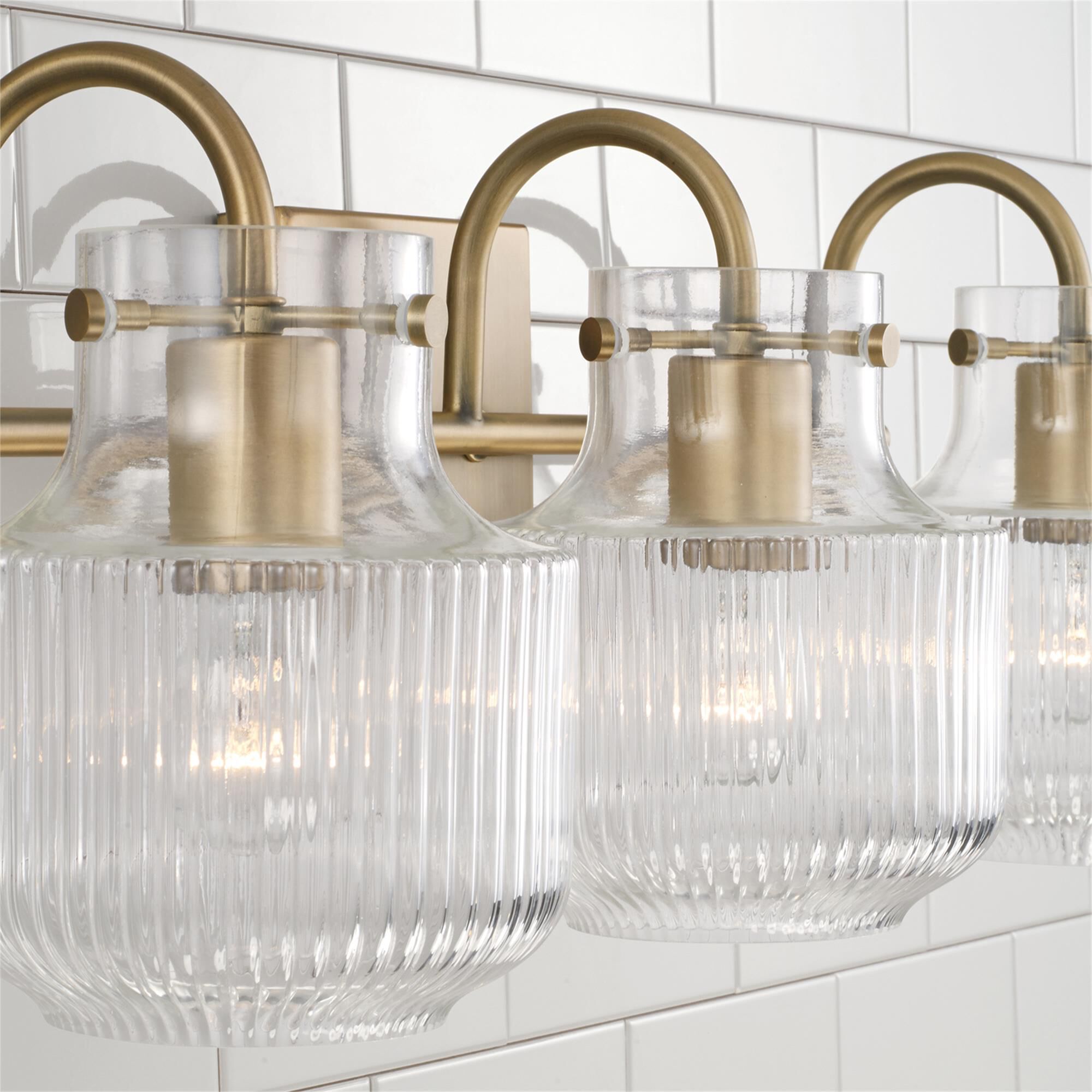 Shown in Aged Brass finish and Clear Fluted glass