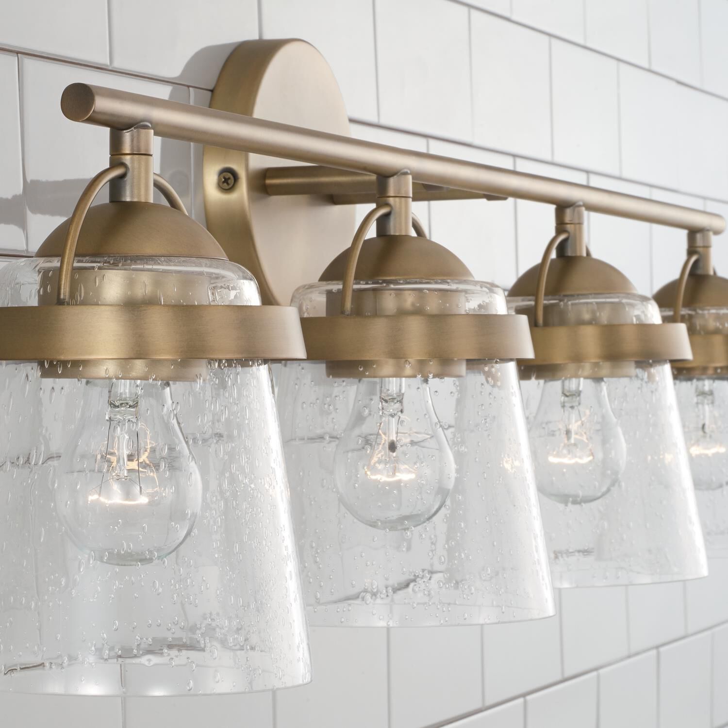 Shown in Aged Brass finish and Clear Seeded glass