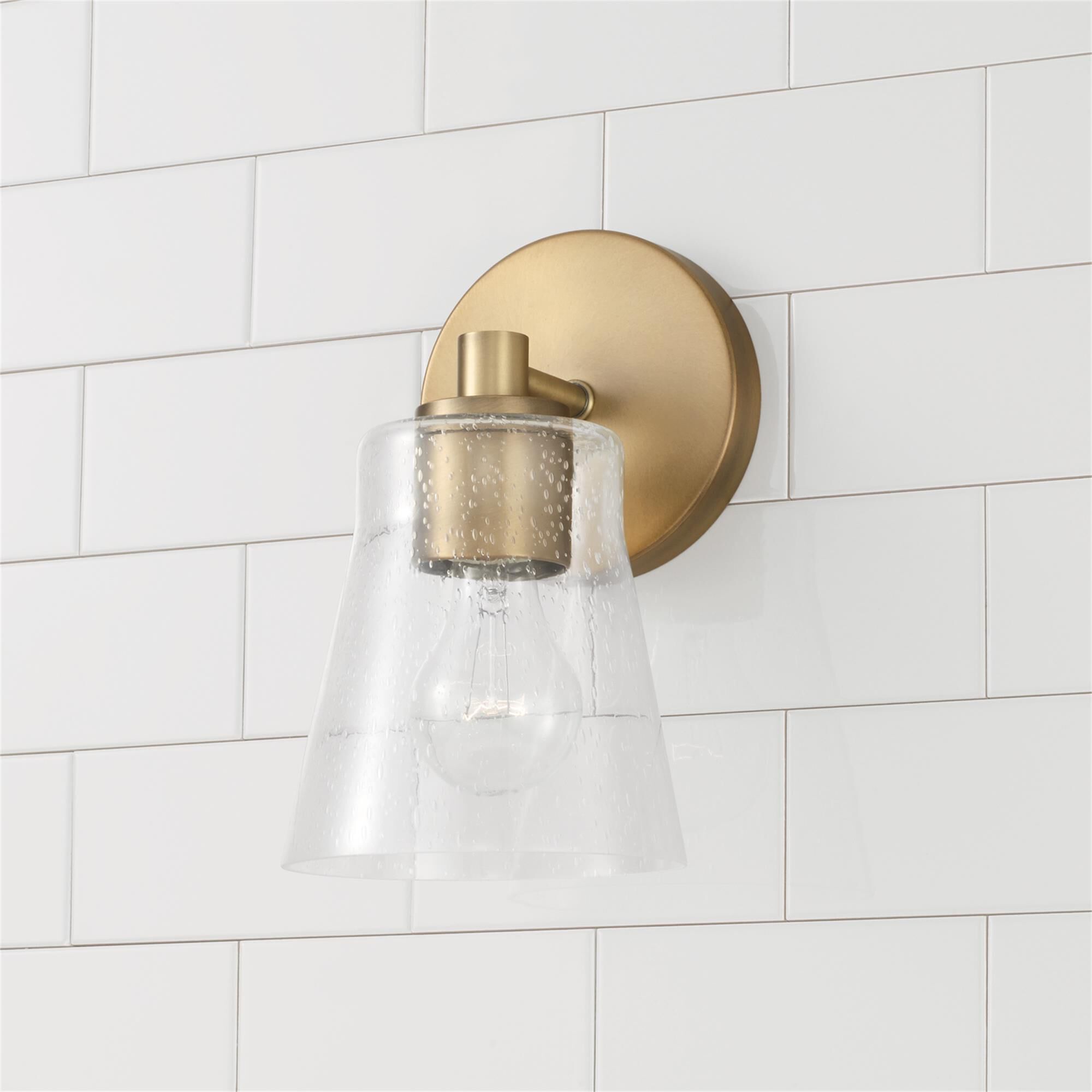 Shown in Aged Brass finish and Clear Seeded glass