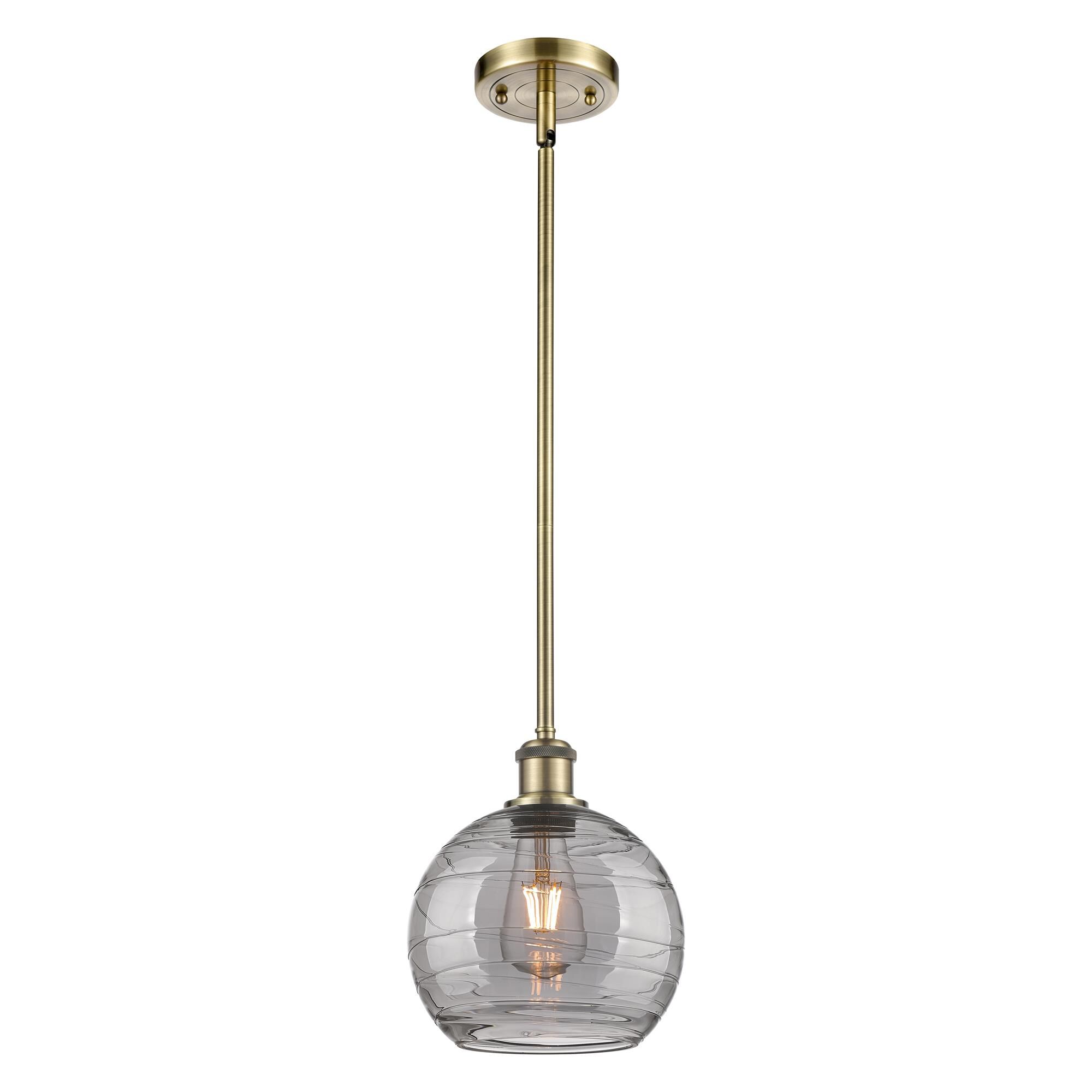 Shown in Antique Brass finish and Light Smoke Deco Swirl glass