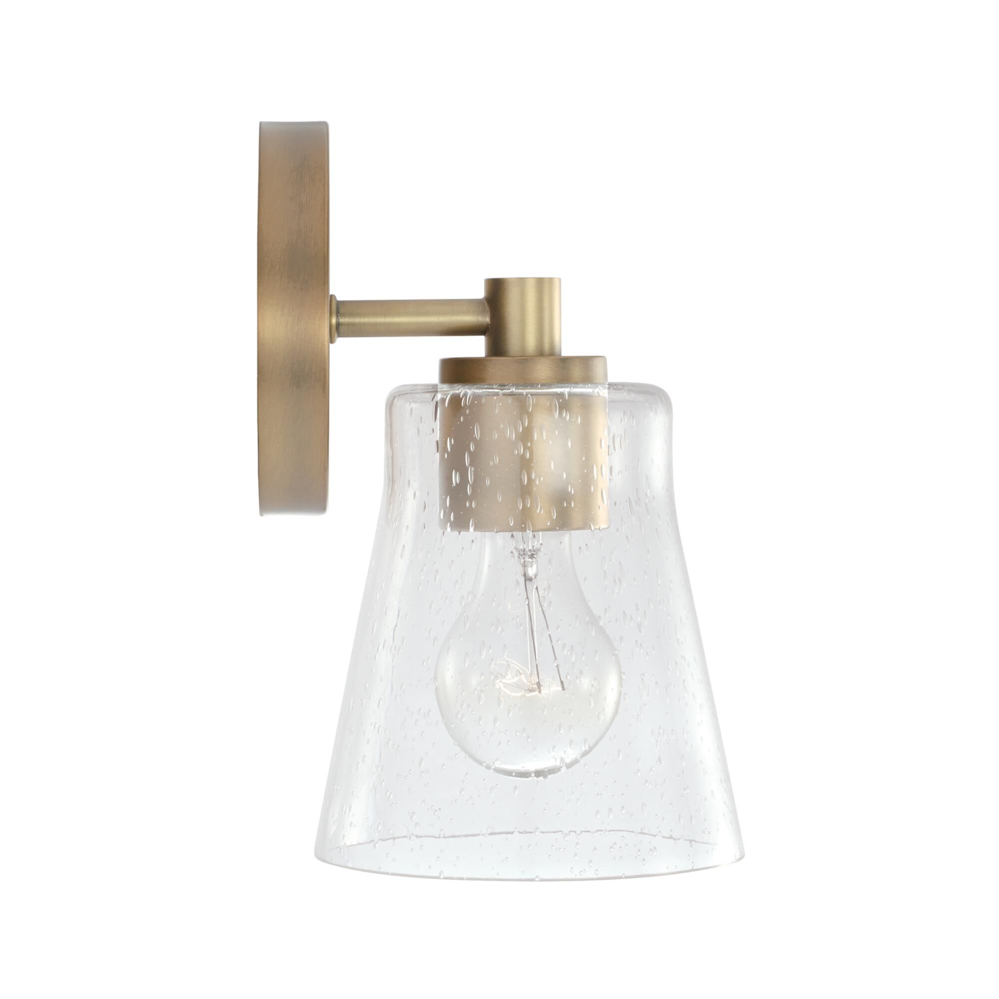 Shown in Aged Brass finish and Clear Seeded glass