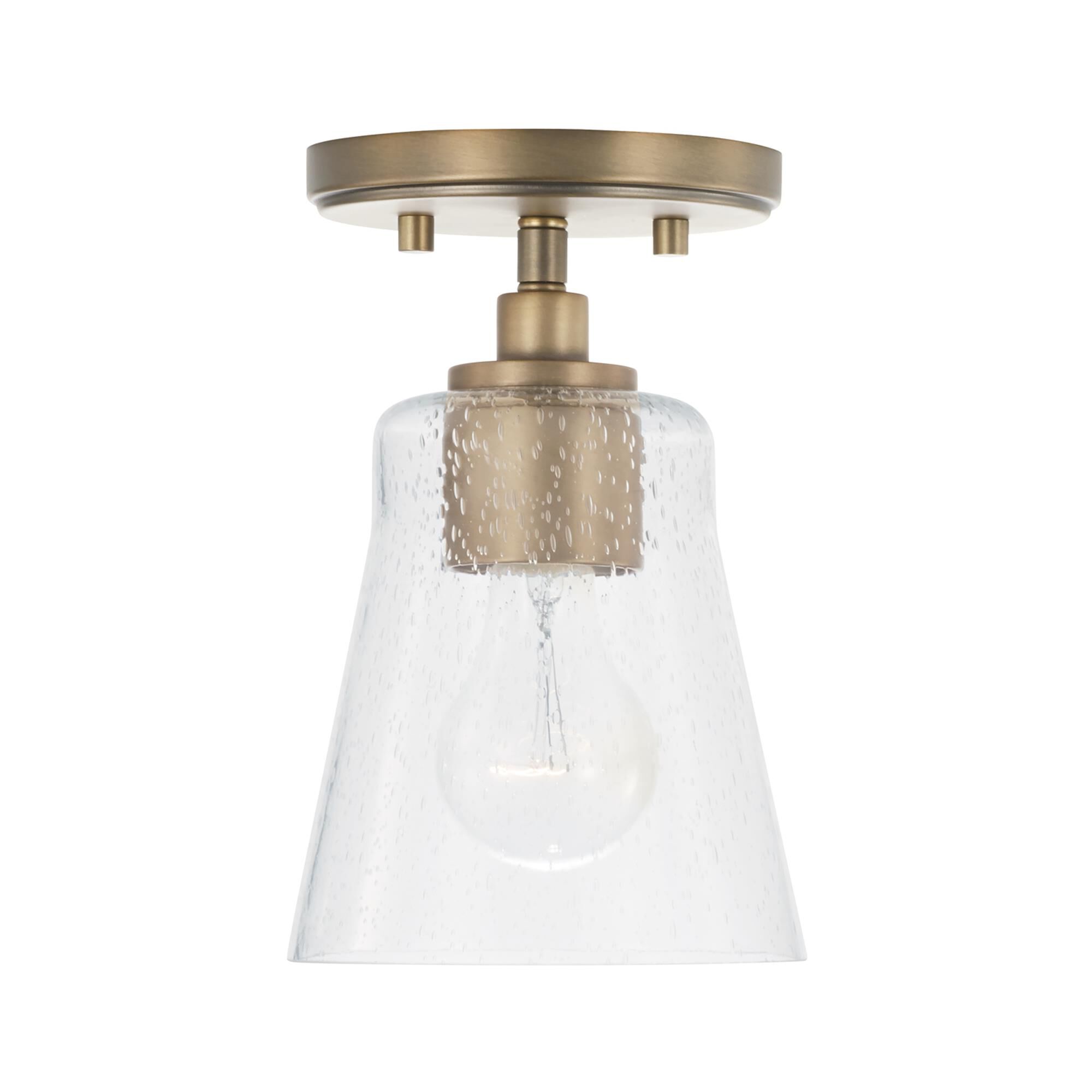 Shown in Aged Brass finish and Clear Seeded glass