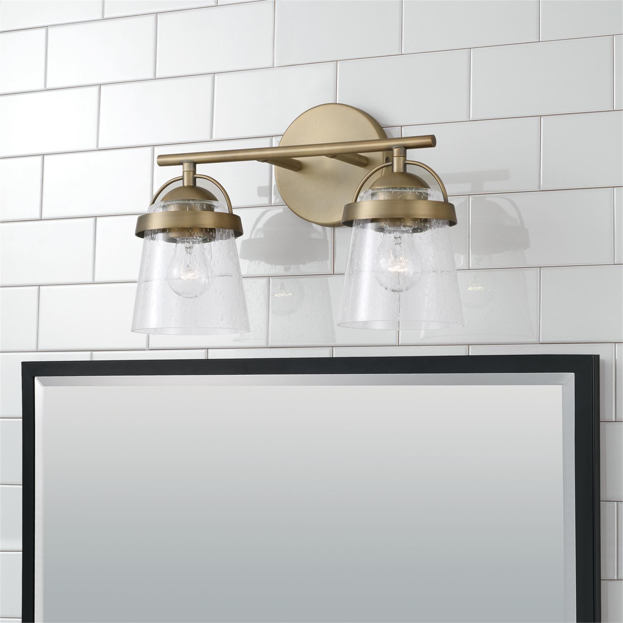 Shown in Aged Brass finish and Clear Seeded glass