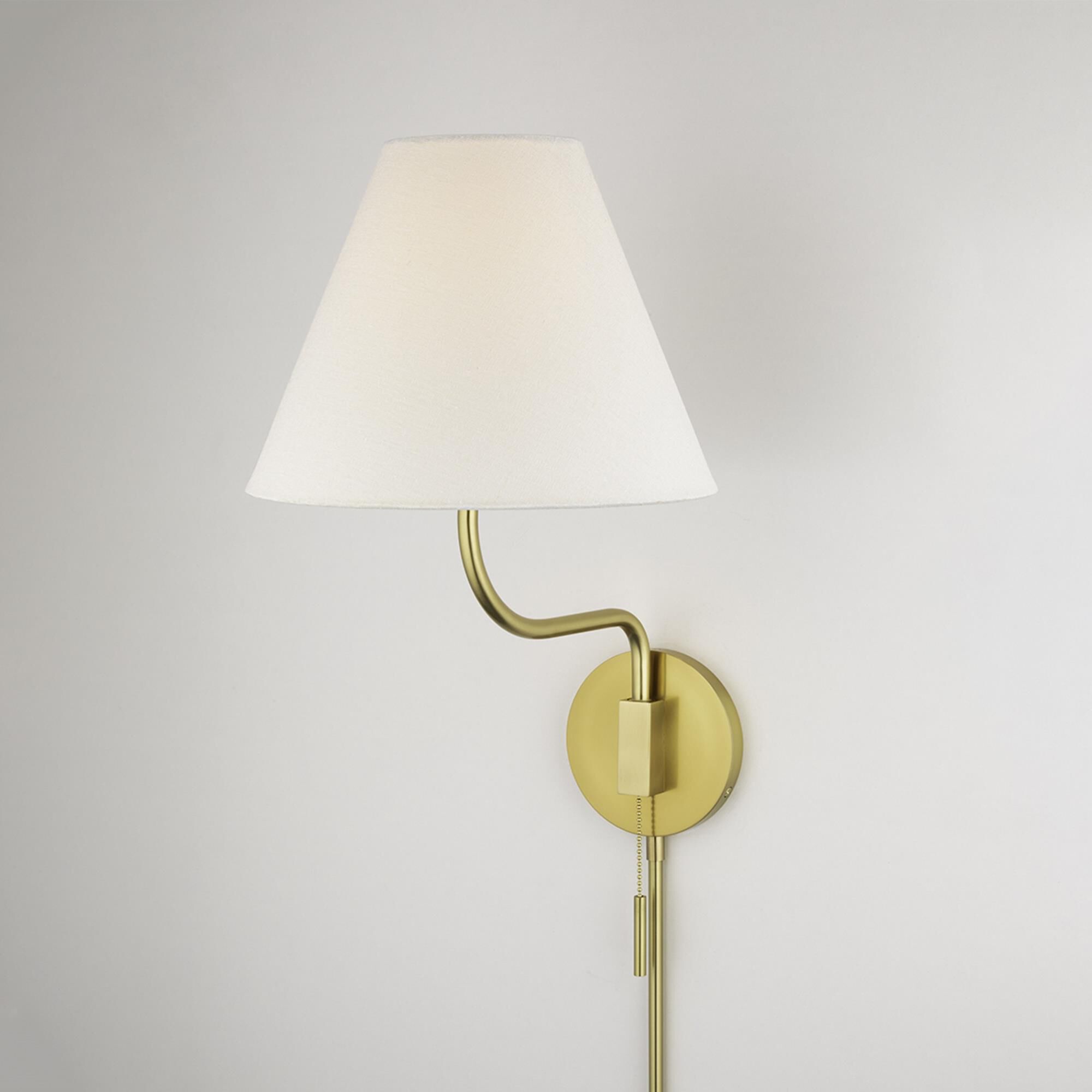 Shown in Aged Brass finish and White Linen shade