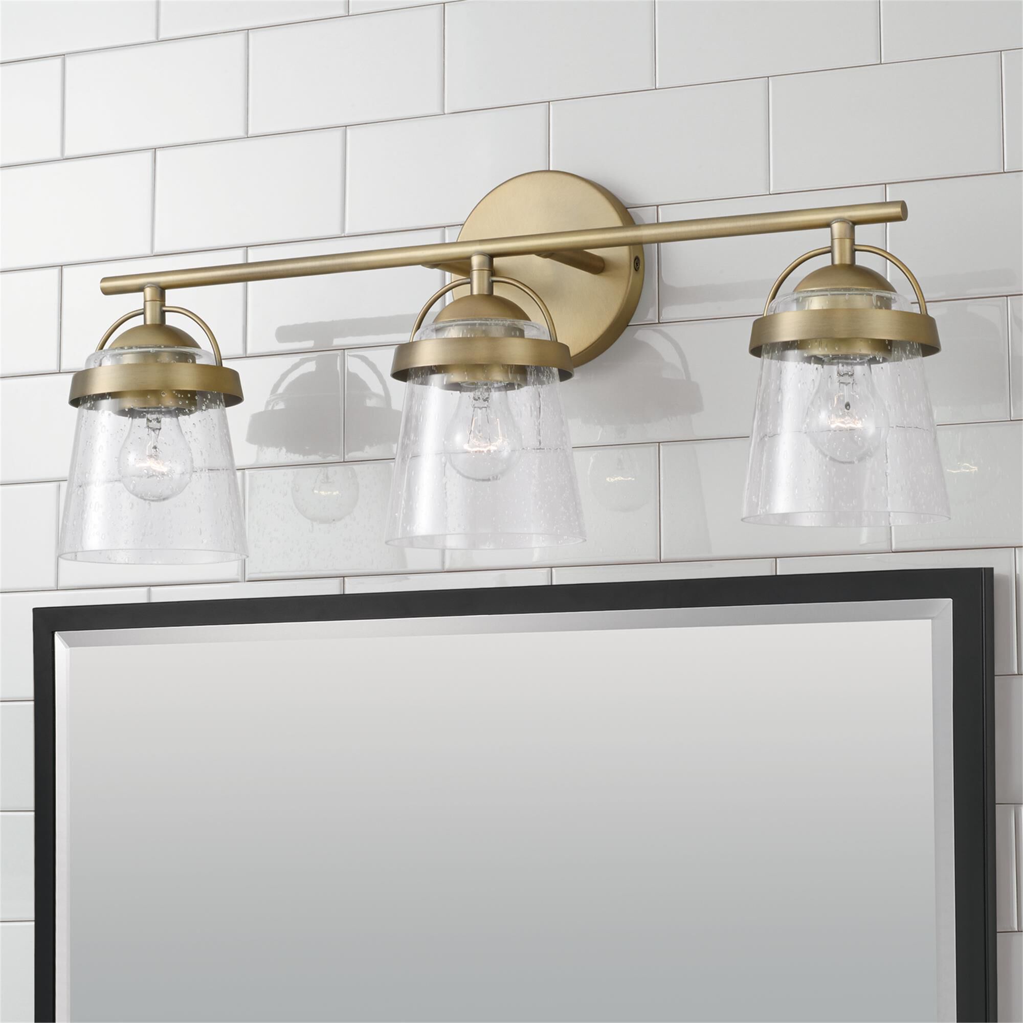 Shown in Aged Brass finish and Clear Seeded glass