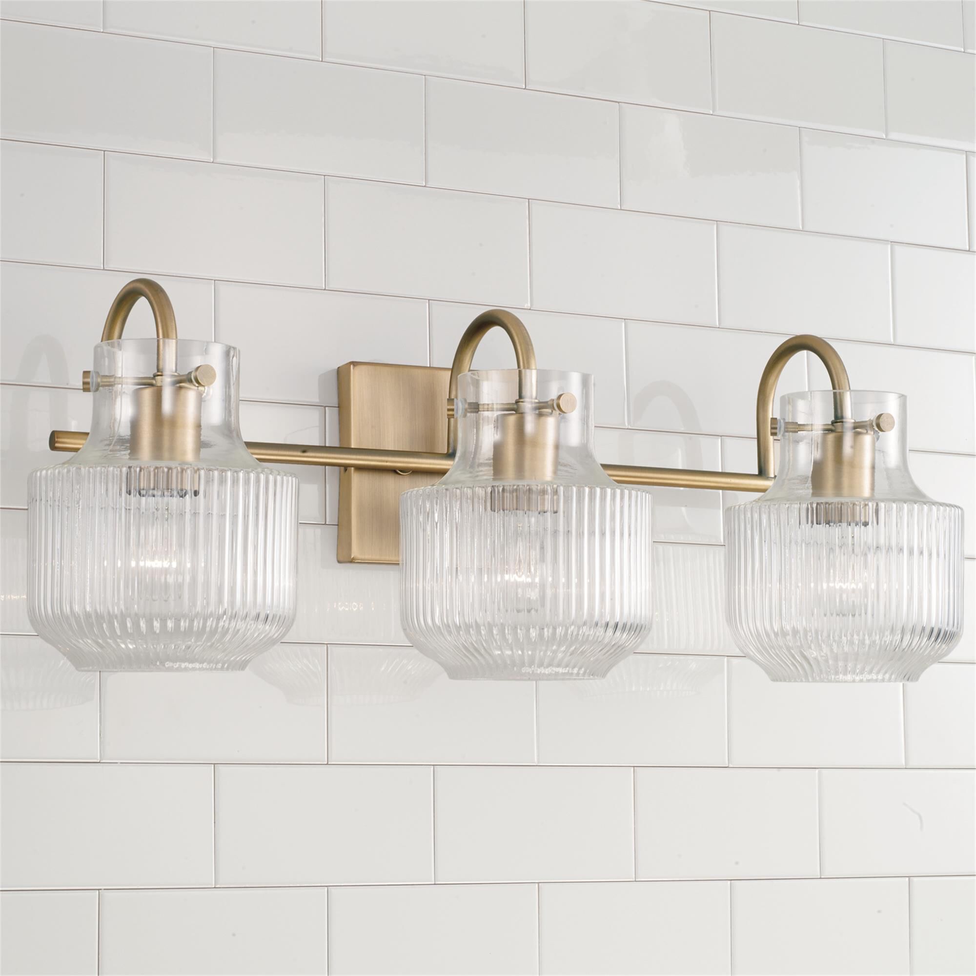 Shown in Aged Brass finish and Clear Fluted glass