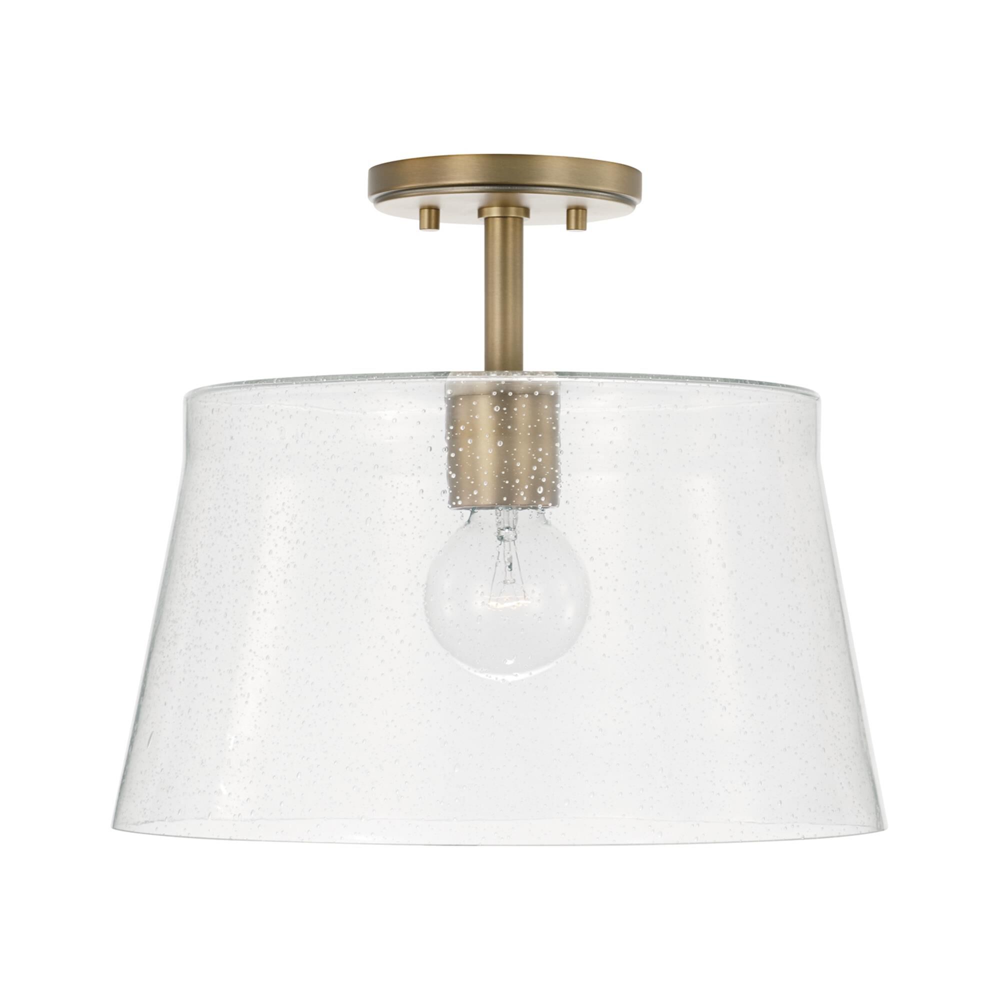 Shown in Aged Brass finish and Clear Seeded glass