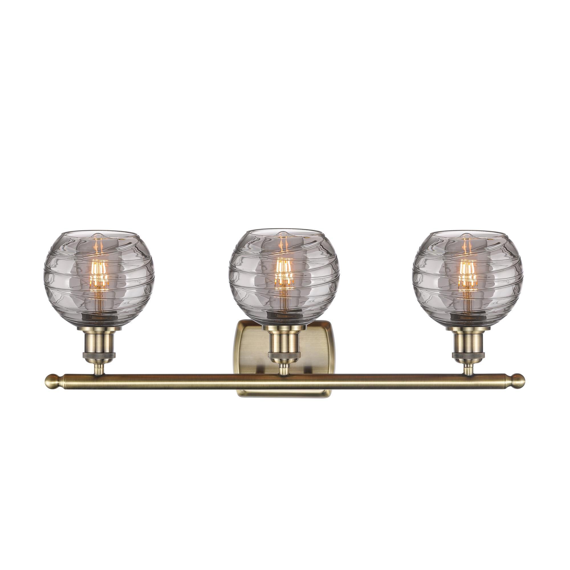 Shown in Antique Brass finish and Light Smoke Deco Swirl glass