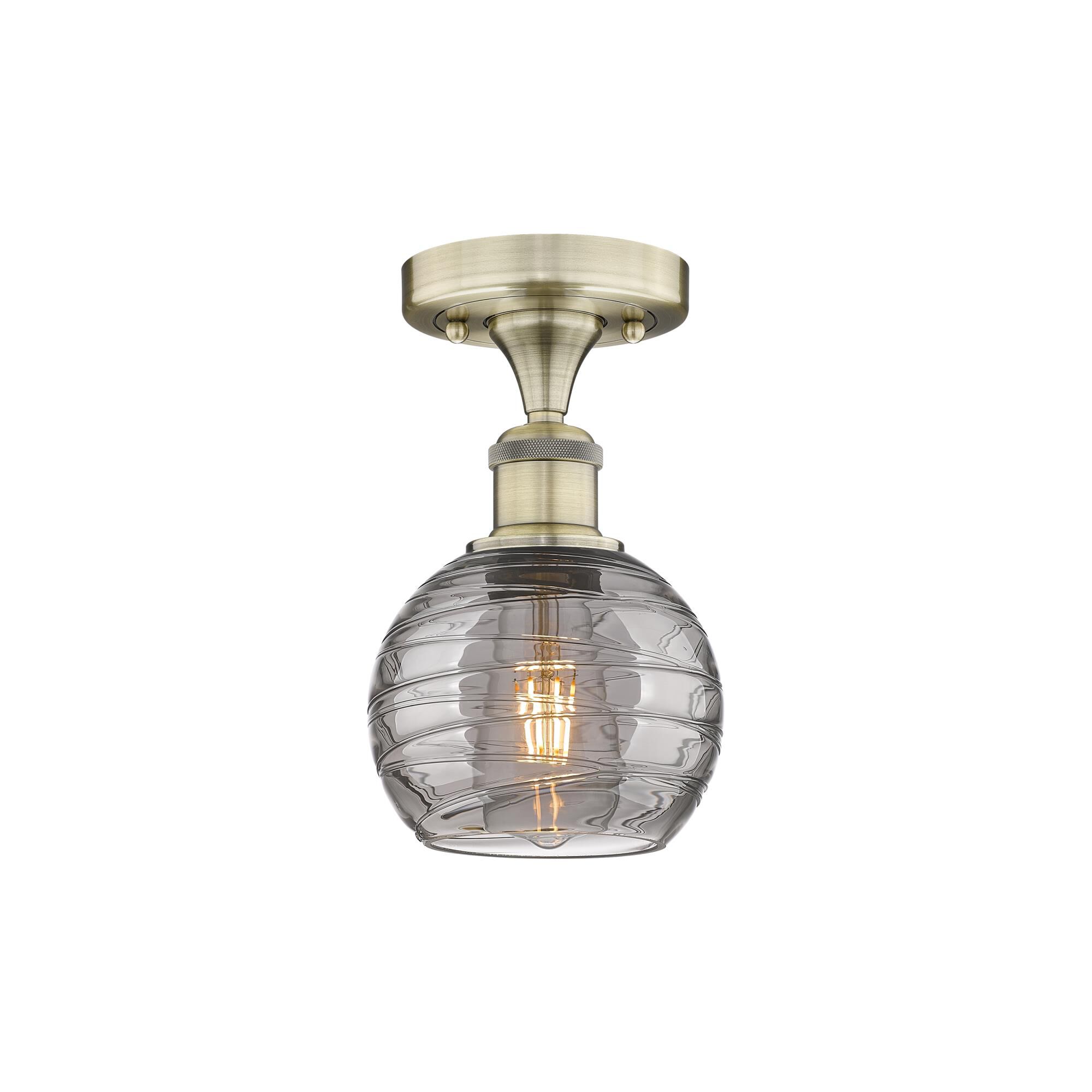 Shown in Antique Brass finish and Light Smoke Deco Swirl glass