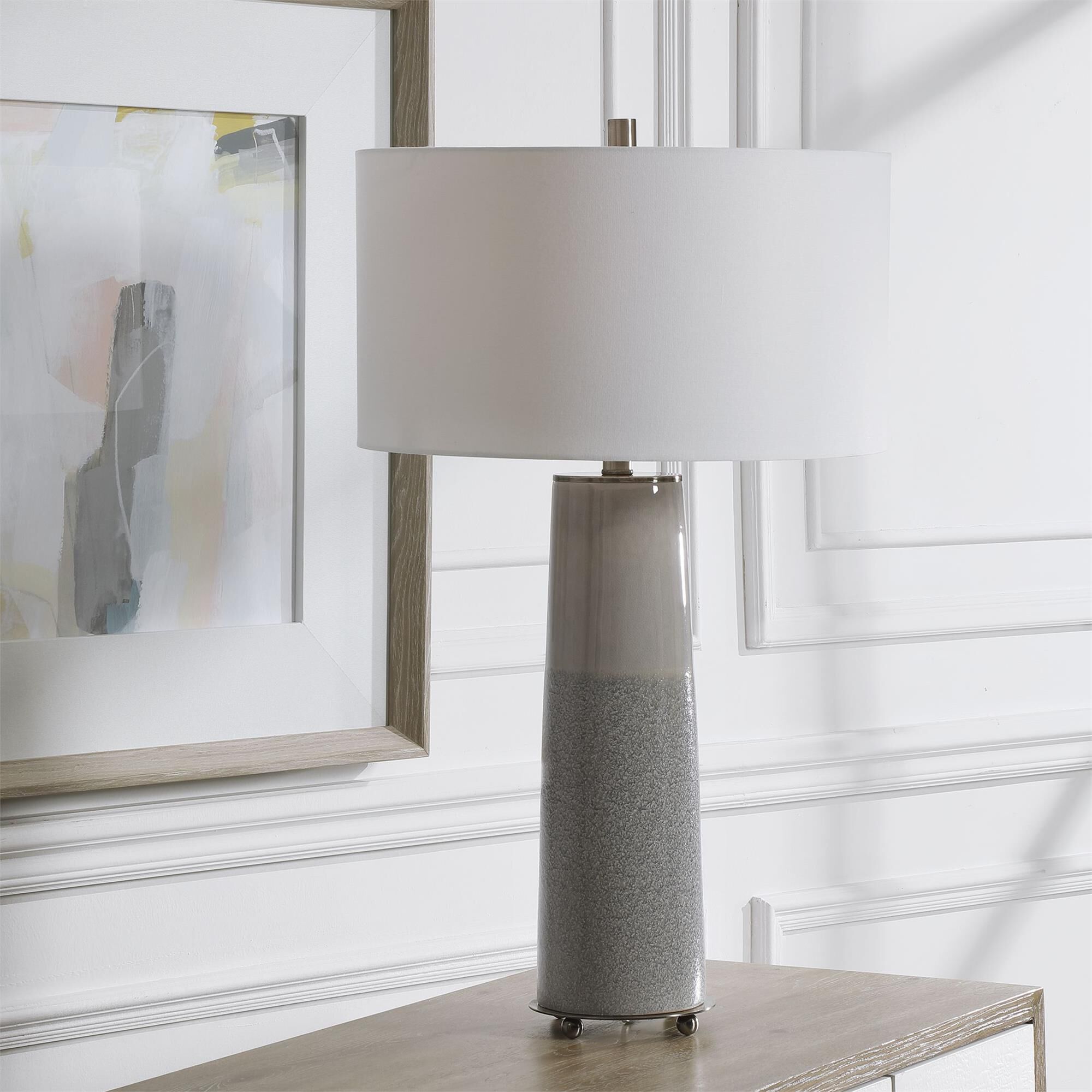 Shown in Sleek And Contemporary, This Ceramic Table Lamp Showcases A Two Tone Light Gray Glaze With A Gloss S finish and Round Drum Hardback shade