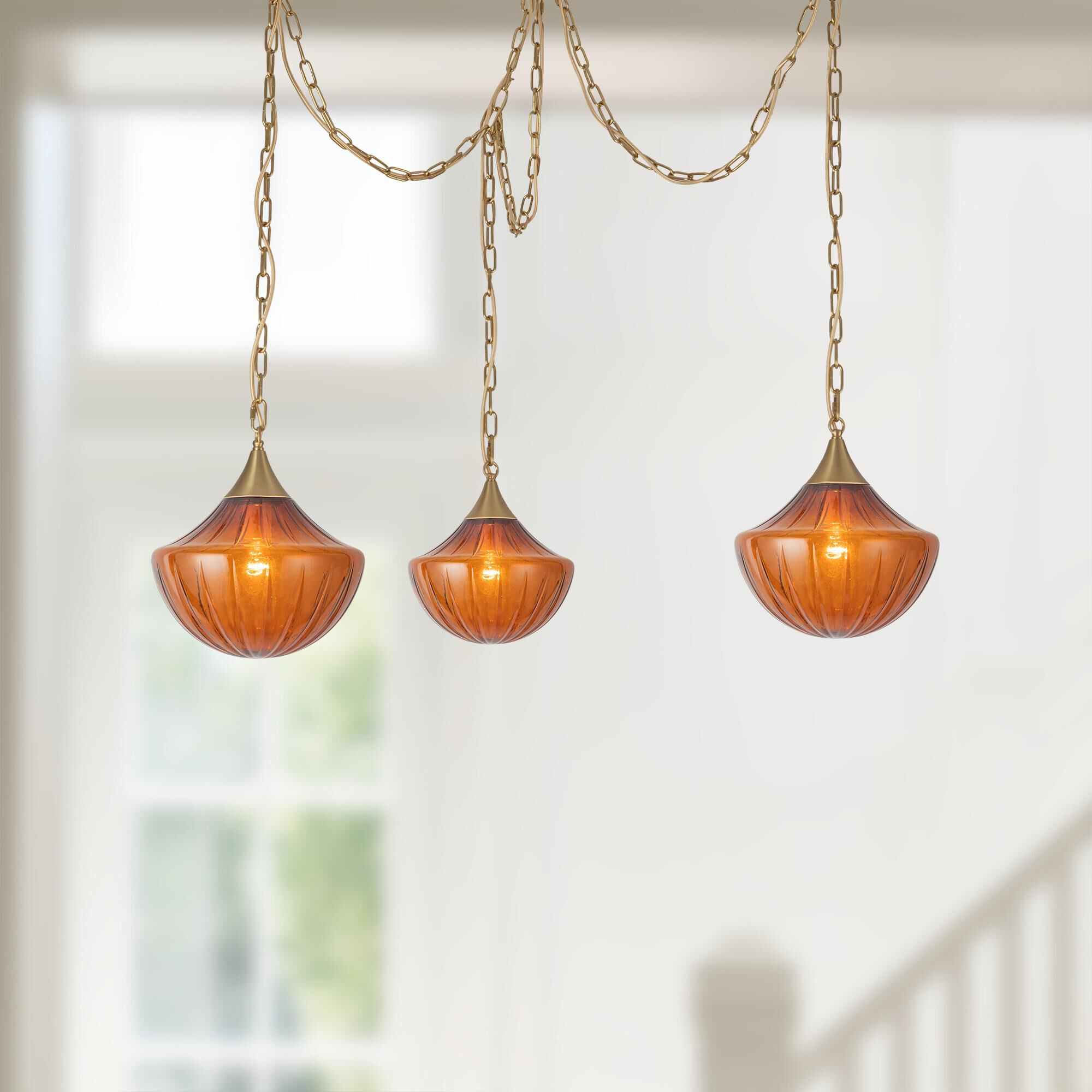 Shown in Brushed Gold finish and Amber Ribbed glass