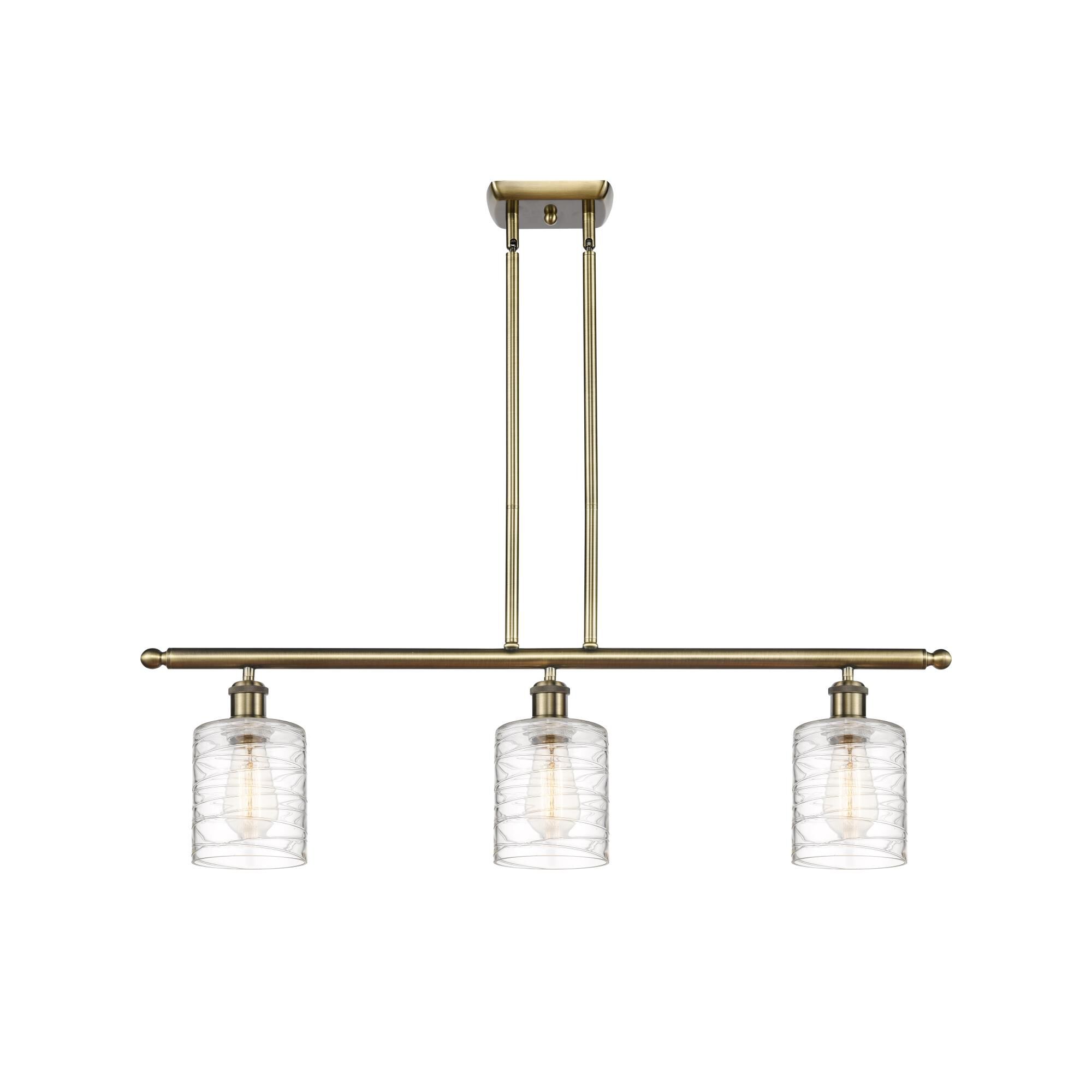 Shown in Antique Brass finish and Deco Swirl Cobbleskill glass