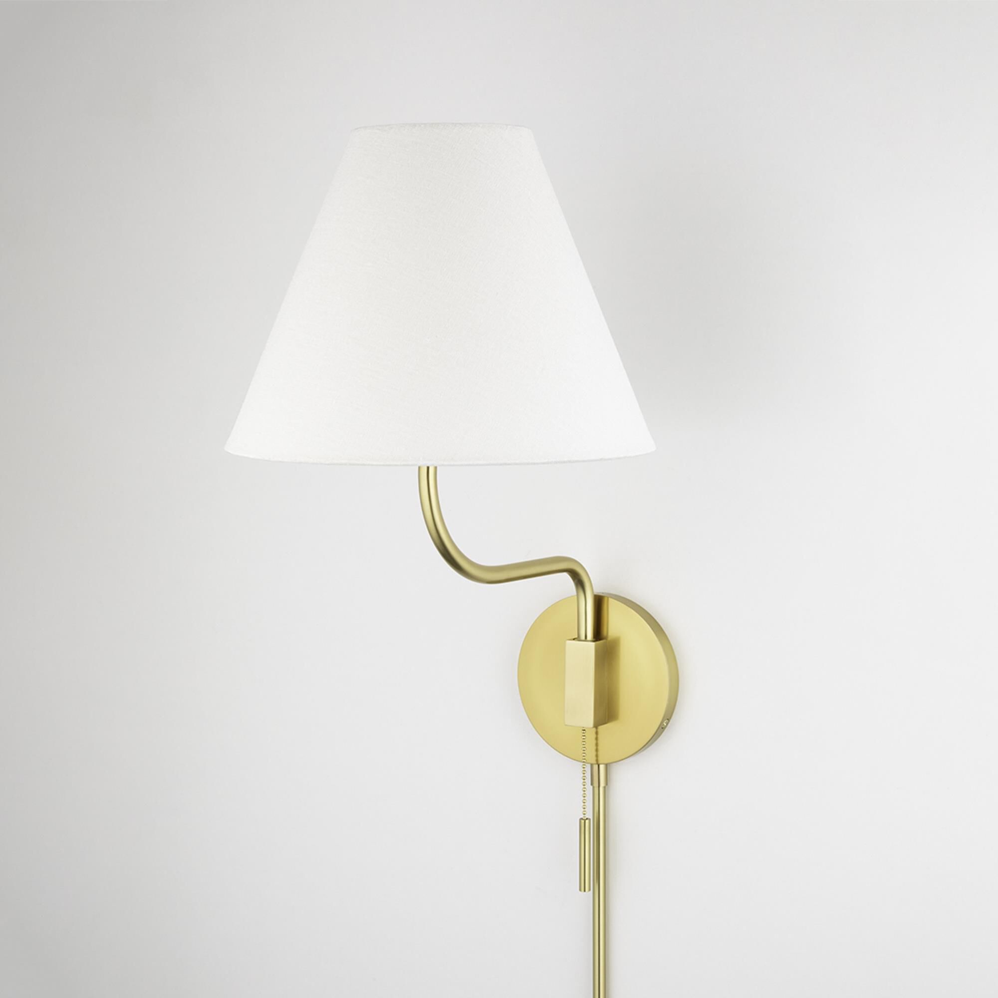 Shown in Aged Brass finish and White Linen shade