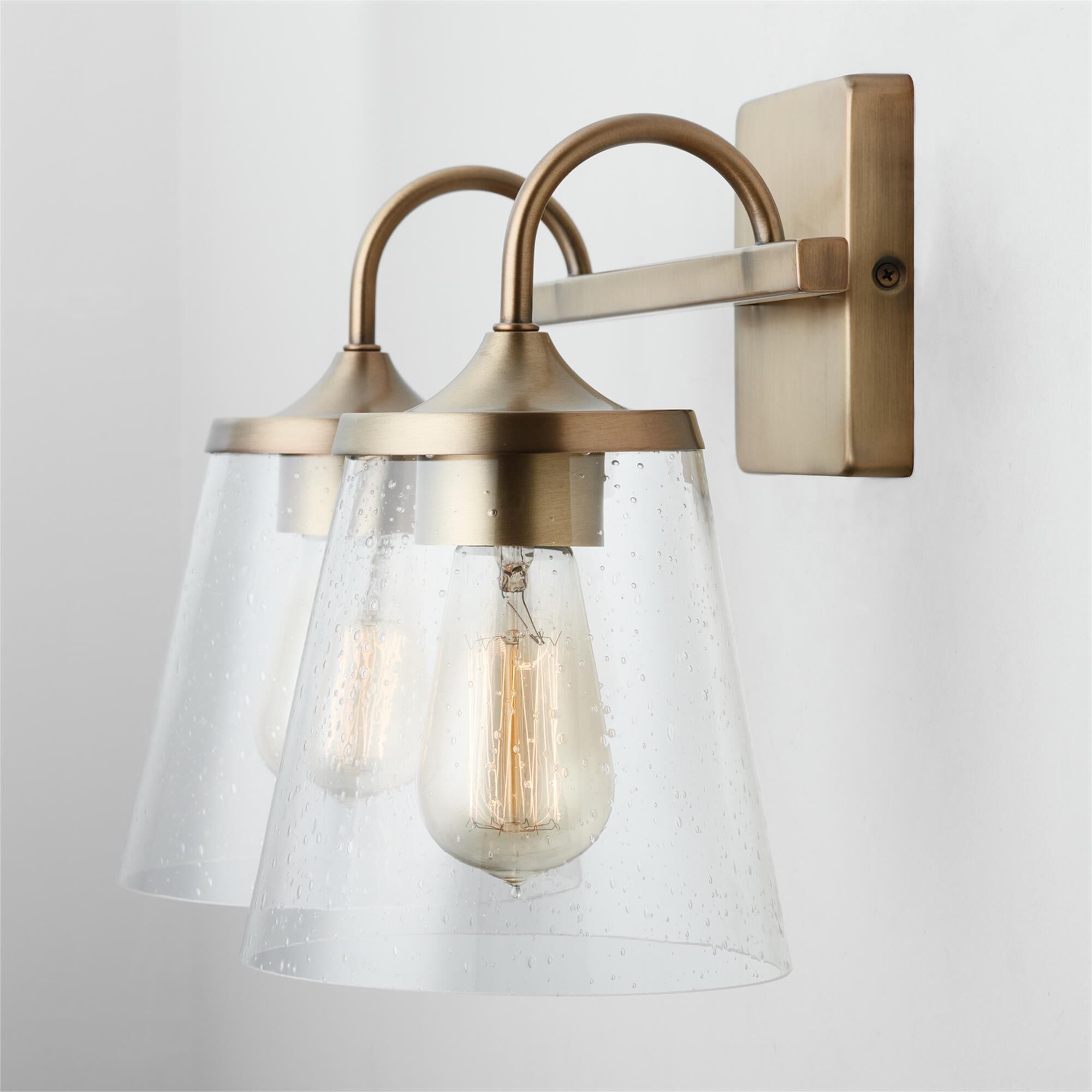 Shown in Aged Brass finish and Clear Seeded glass