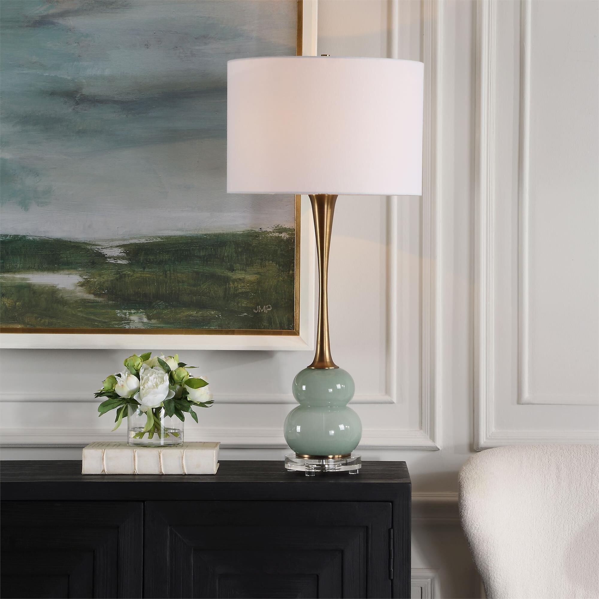 Shown in The Sanctuary Table Lamp Features A Curvy, Greenish-Gray Glass Body Paired With A Fluted Style Neck  finish and Round Drum Hardback shade