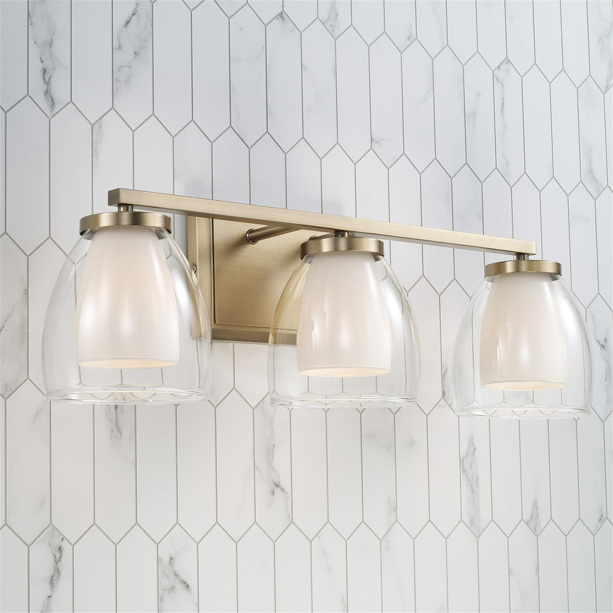 Shown in Aged Brass finish and Layered White and Clear glass
