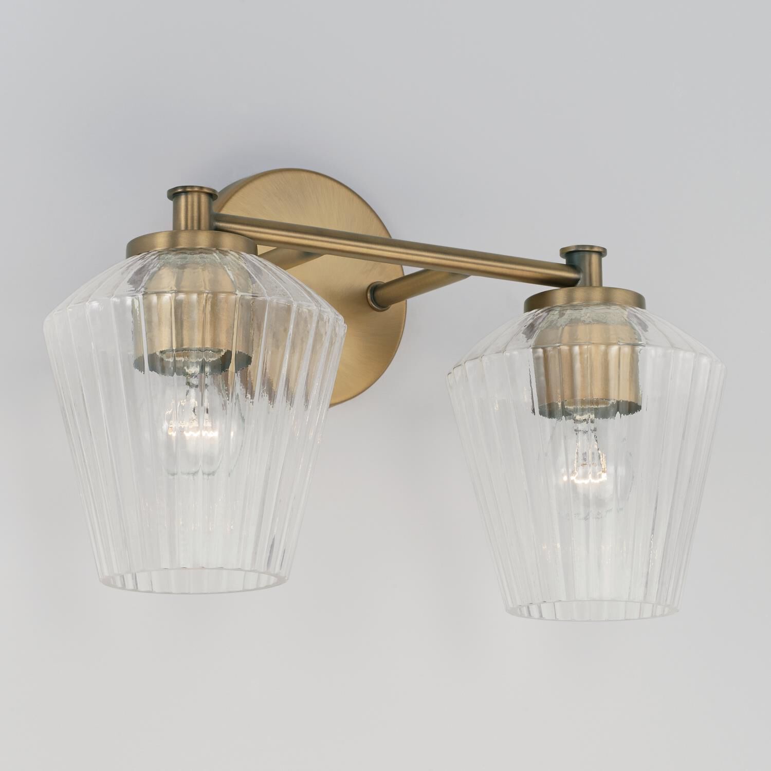 Shown in Aged Brass finish and Clear Fluted glass
