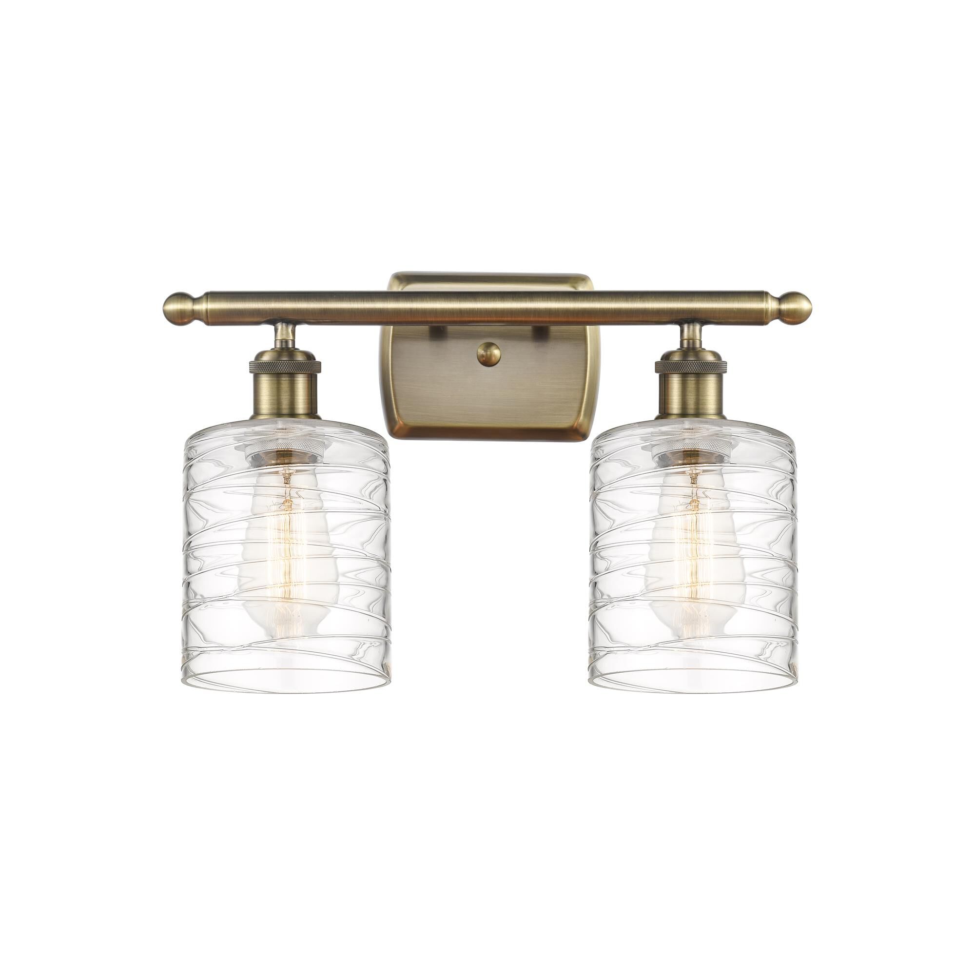 Shown in Antique Brass finish and Deco Swirl Cobbleskill glass