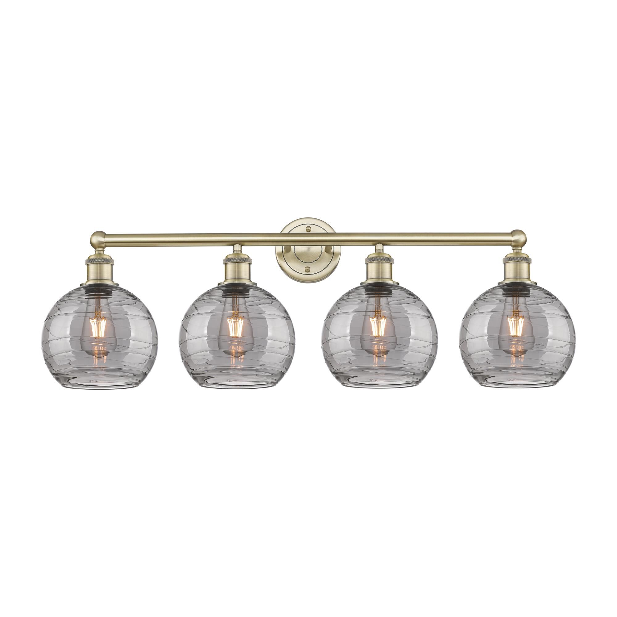 Shown in Antique Brass finish and Light Smoke Deco Swirl glass