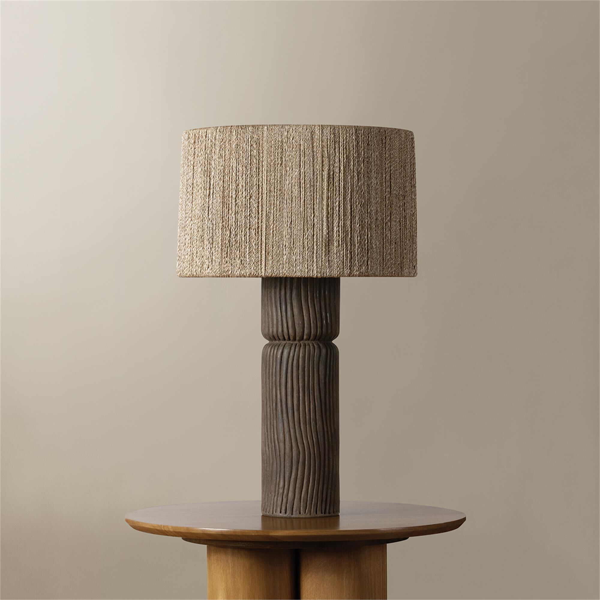 Shown in Patina Brass and Ceramic Shadowed Bark finish and Abaca shade