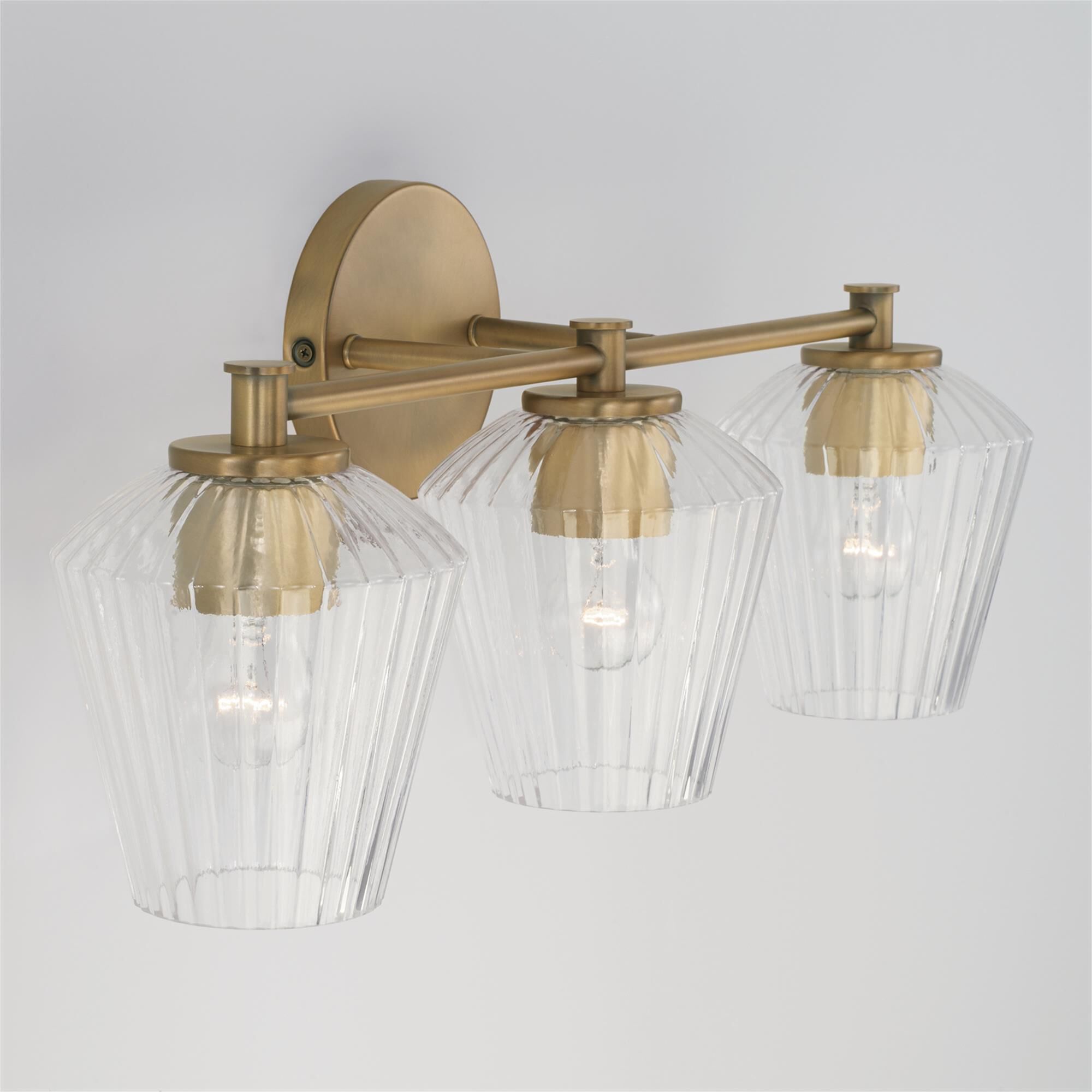 Shown in Aged Brass finish and Clear Fluted glass